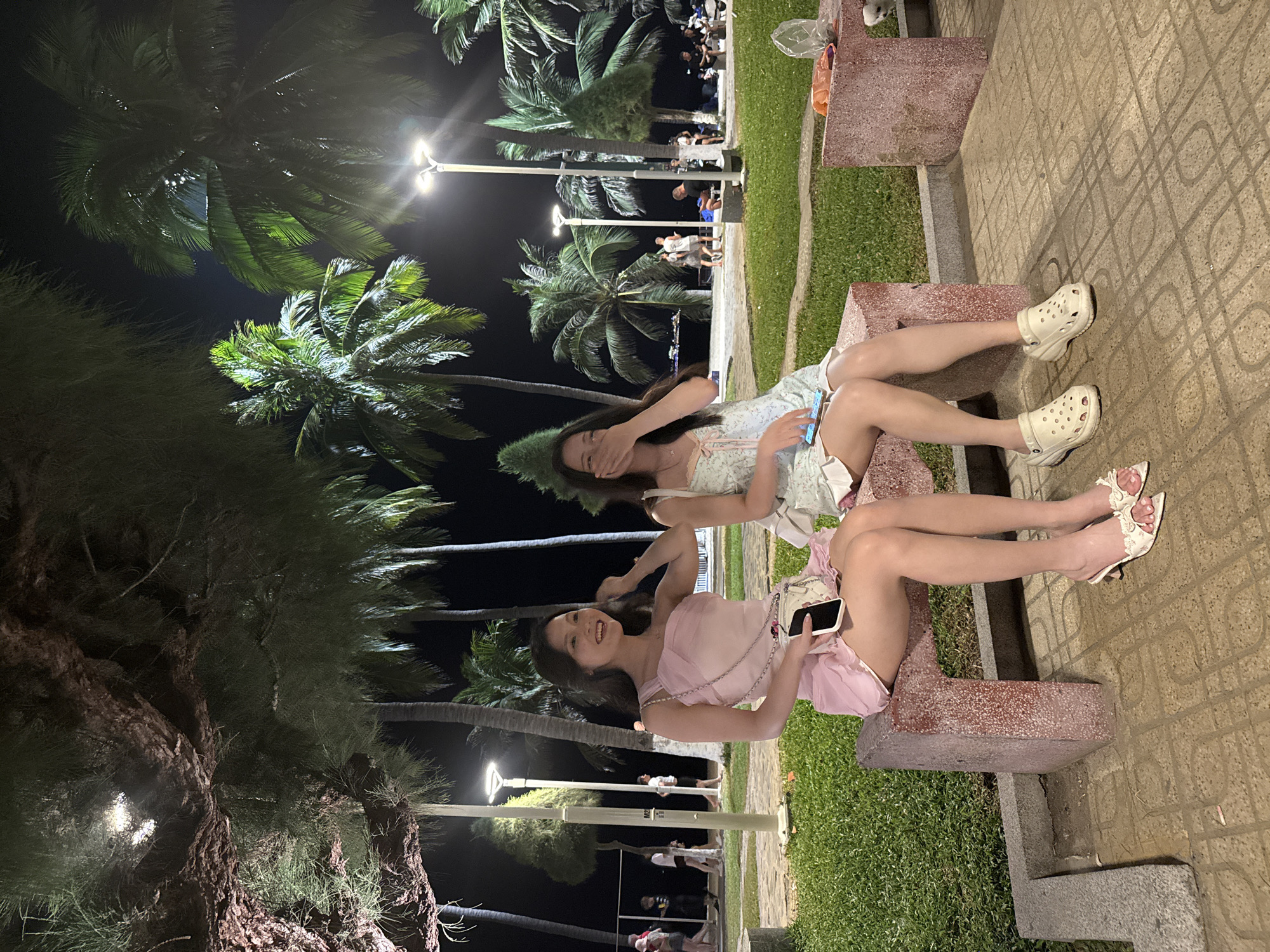Two women share evening moment on Nha Trang bench