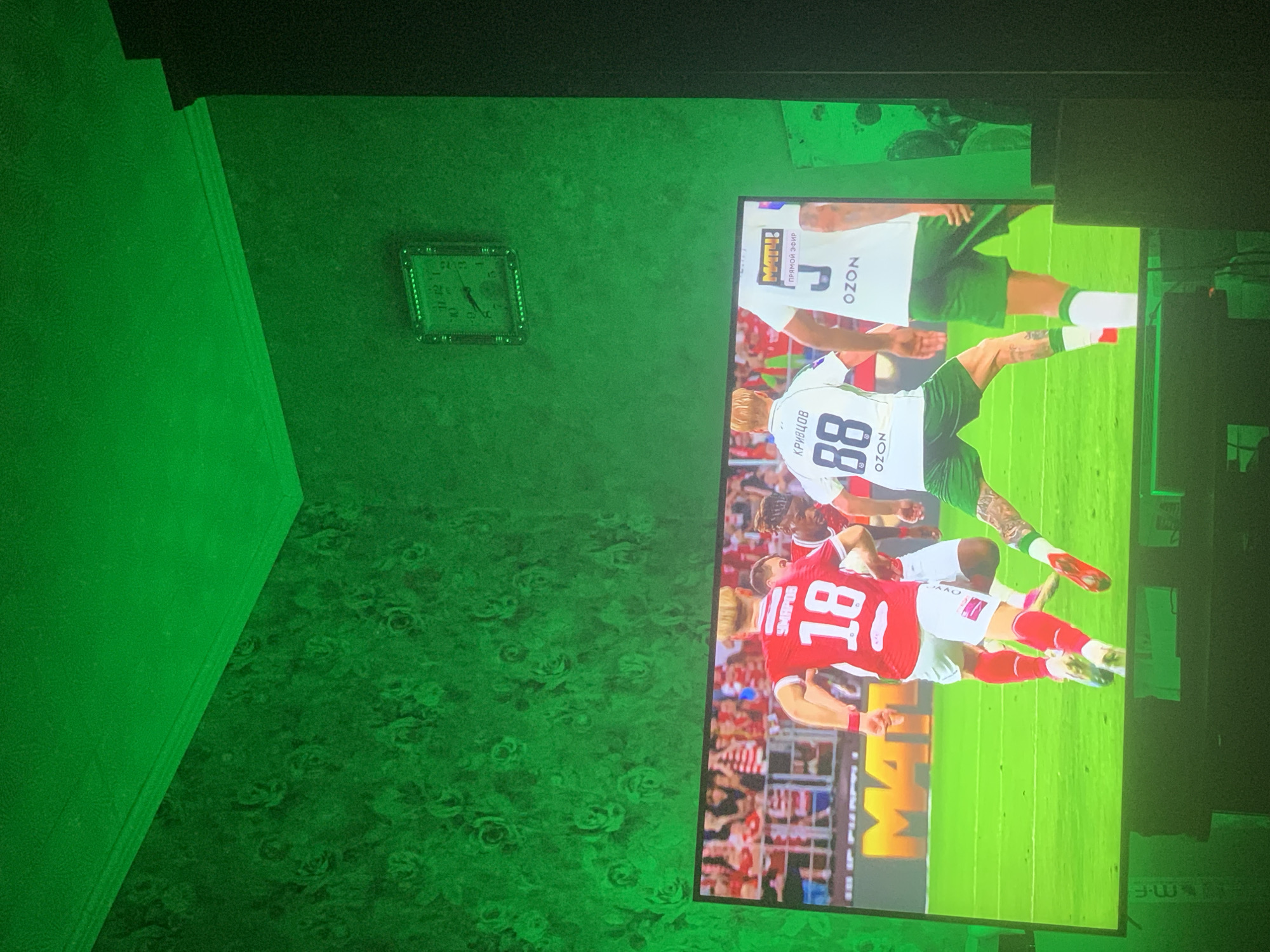Football match on TV in Moscow, mid-game with pitch-side activity