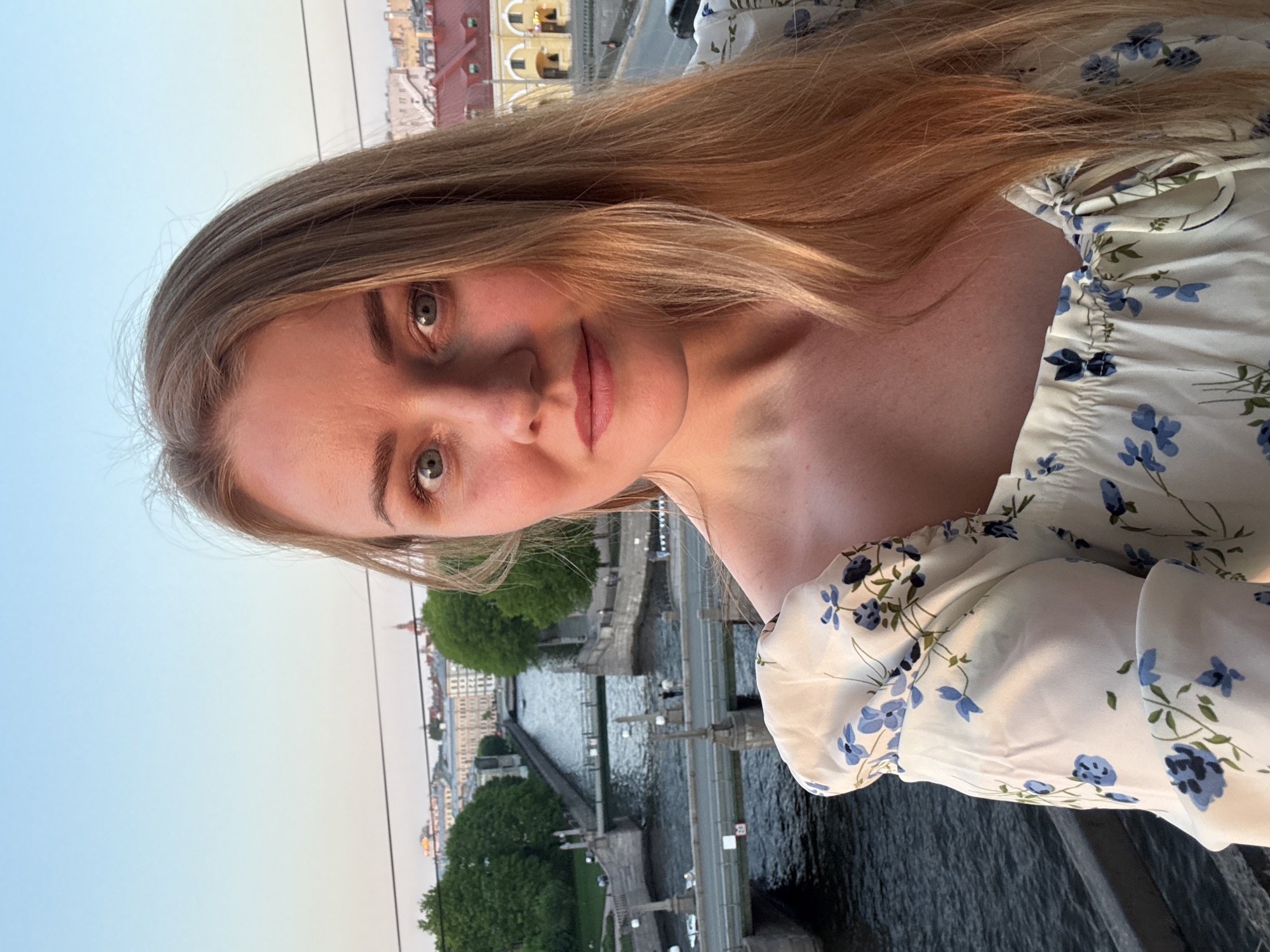 Woman takes sunset selfies overlooking Saint Petersburg riverscape