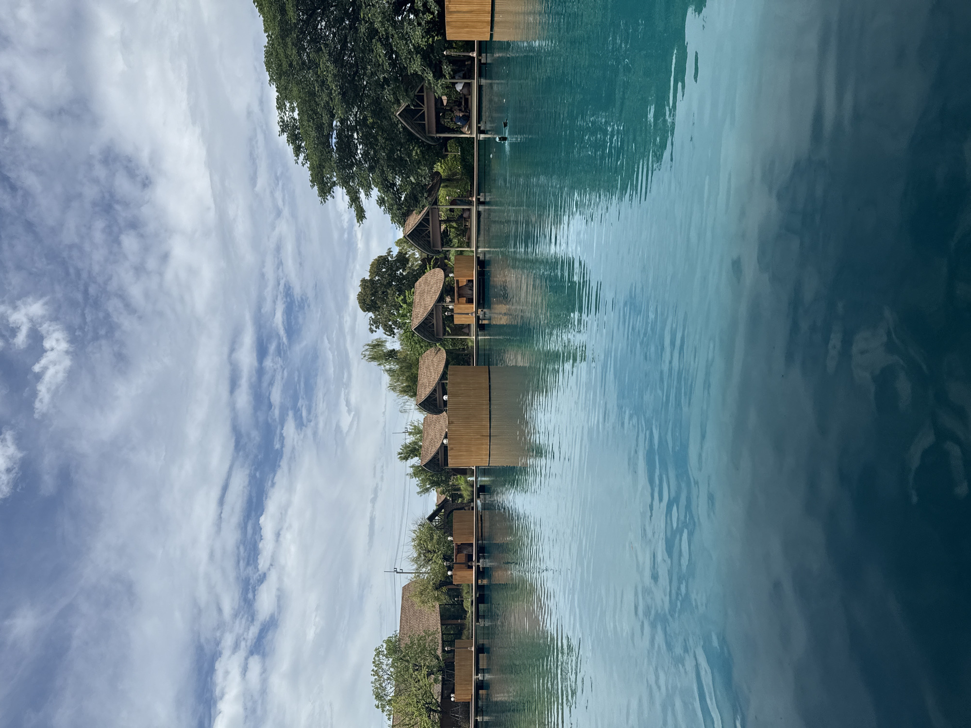 Overwater thatched-roof resort dining area in Sam Phran, Thailand