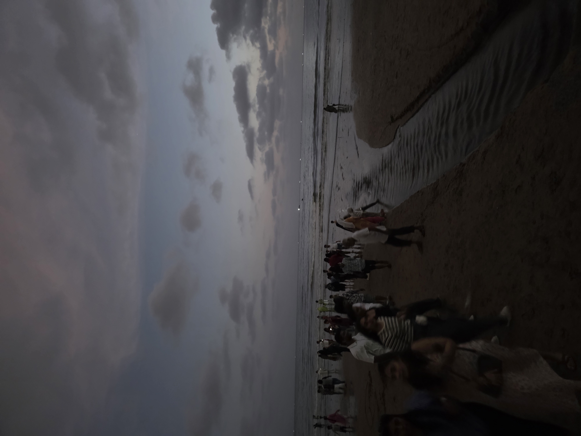 Evening crowds gather at Mumbai beaches under cloudy skies