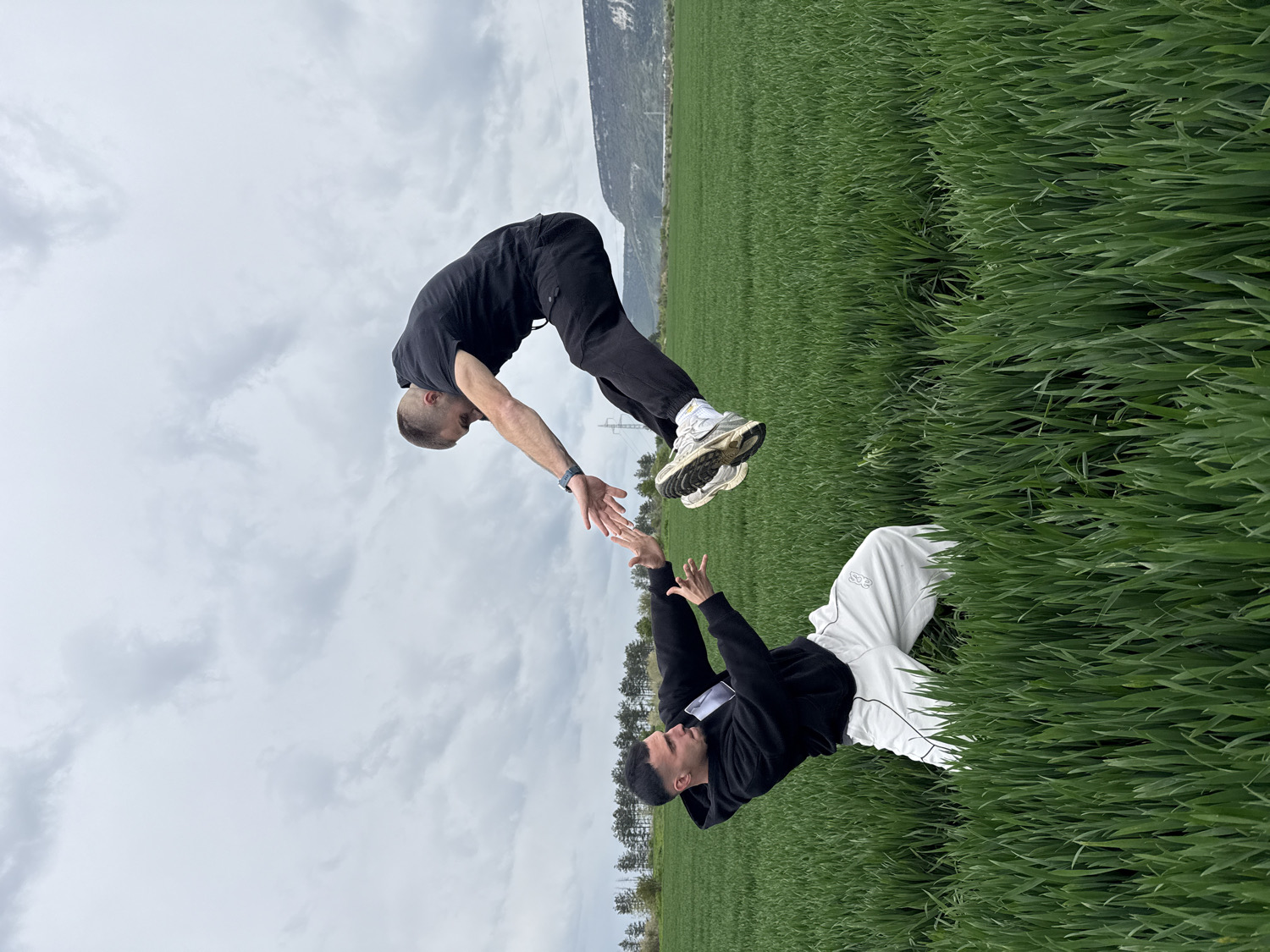 Two men pose synchronously in Bulgarian countryside landscape