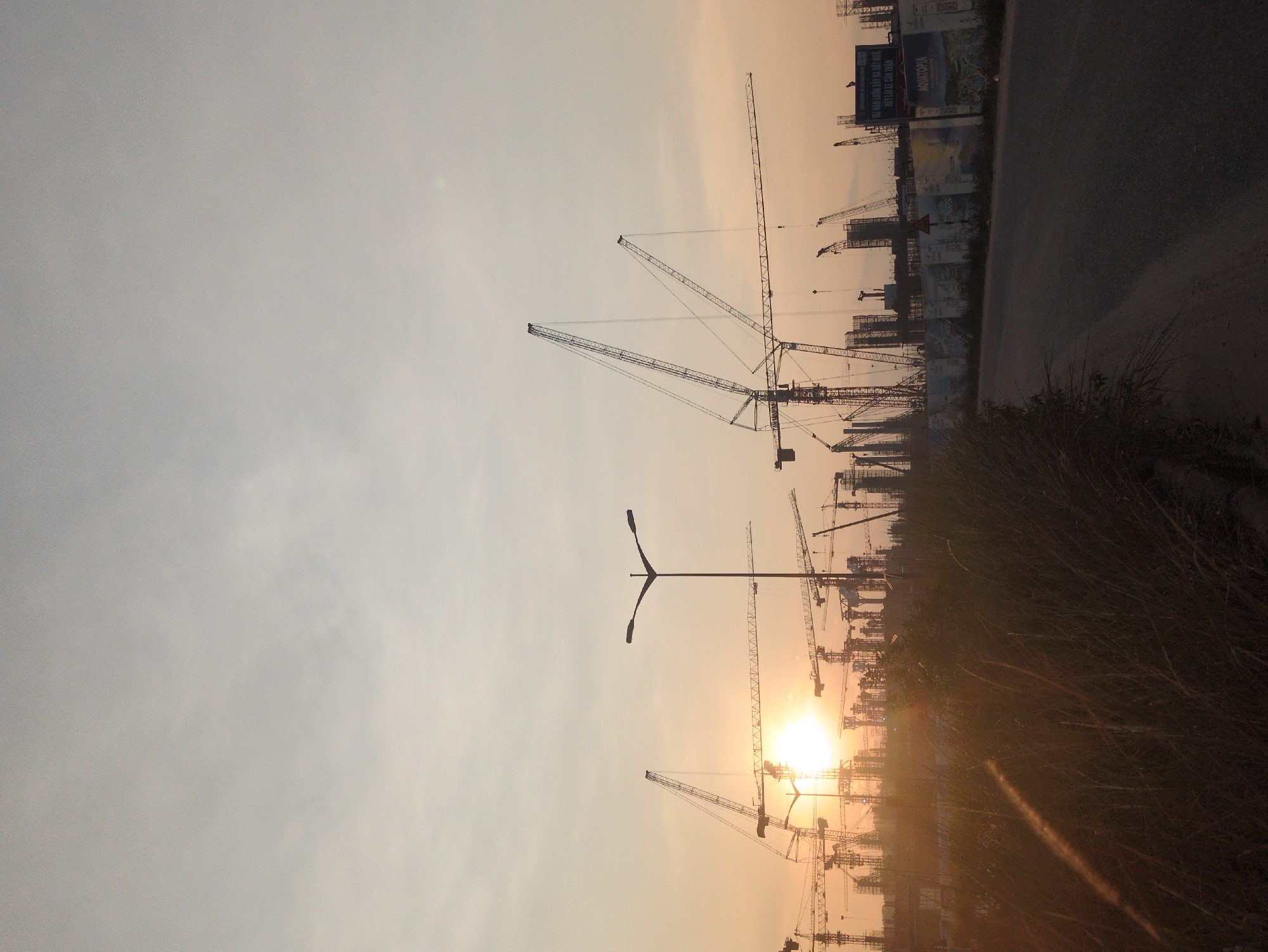 Construction cranes silhouetted against sunrise in Phú Quốc, Vietnam