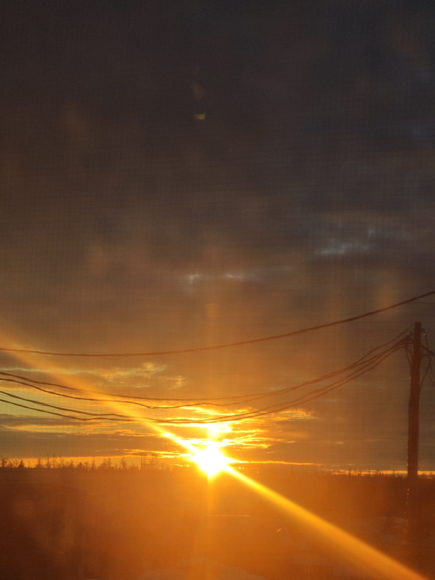 Sunset observed over rural Russian landscape with power lines