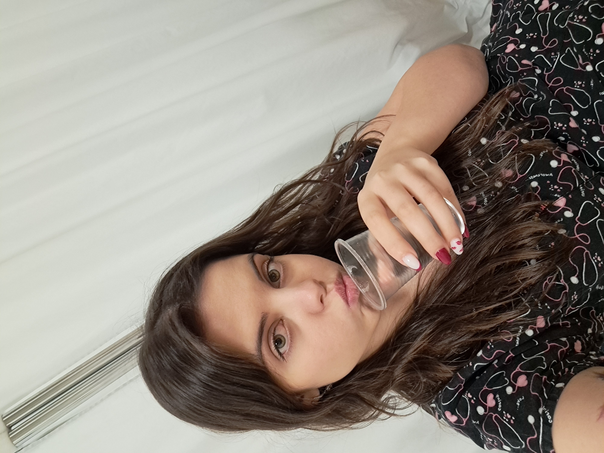 Woman in medical pajamas drinks from cup in Sofia