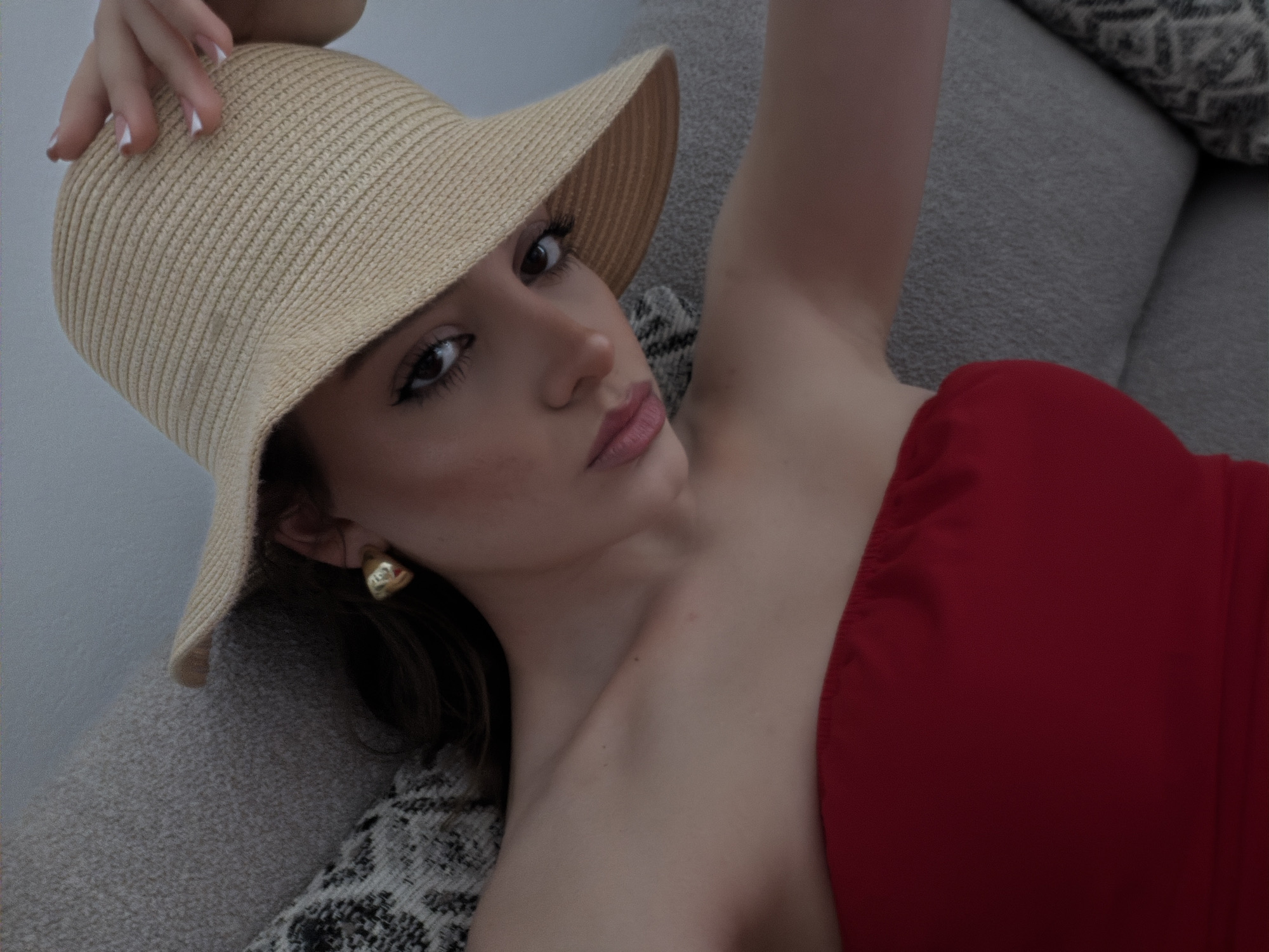 Woman rests on couch indoors in Thira, Greece