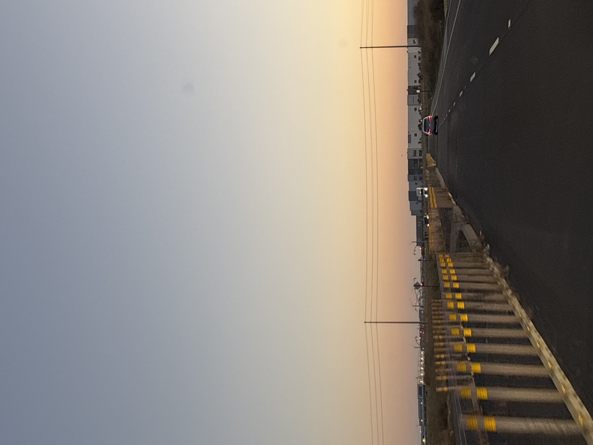 Highway approach to a Sacramento industrial complex at golden hour