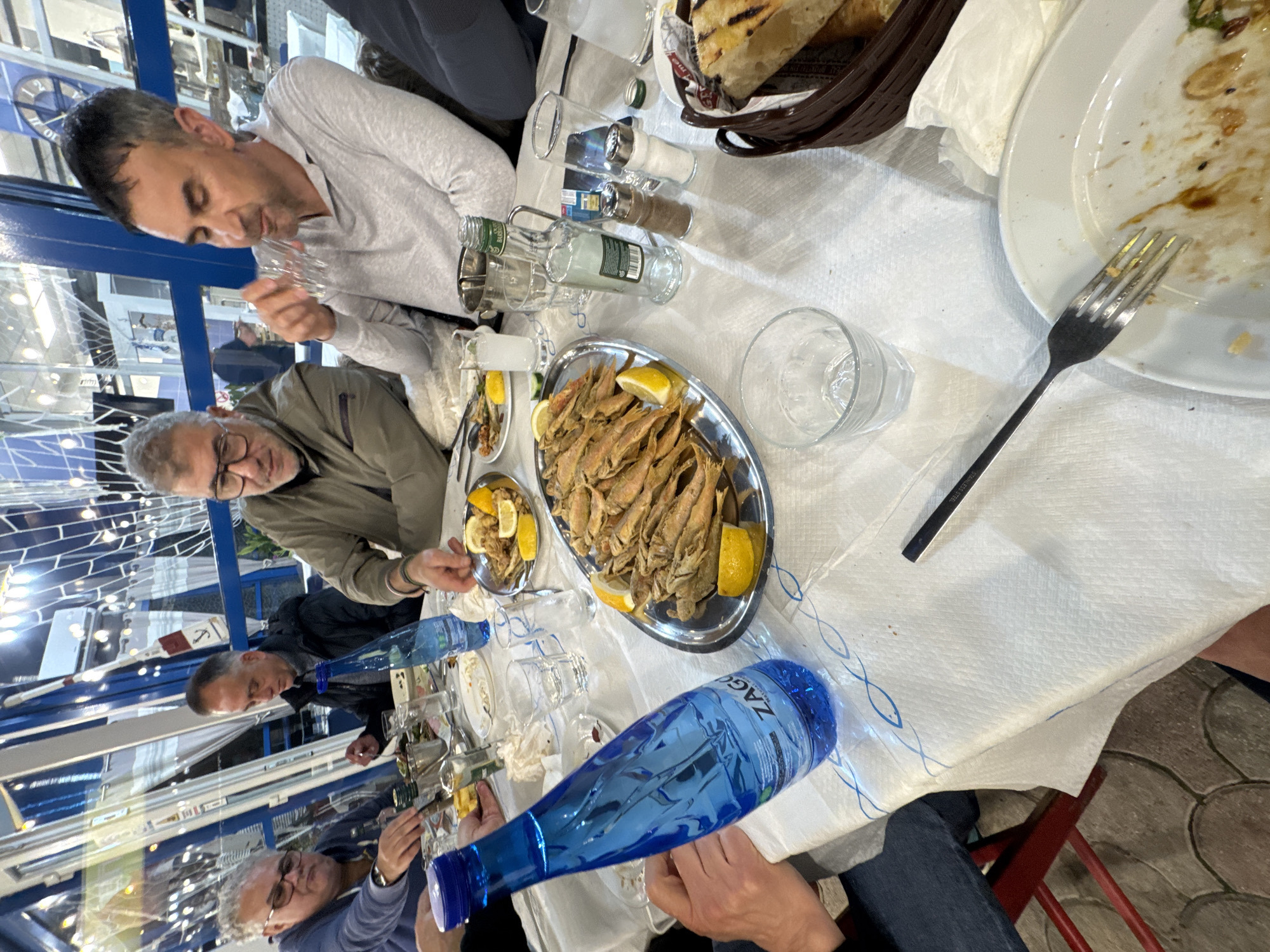 Diners gather for meal at Greek restaurant table