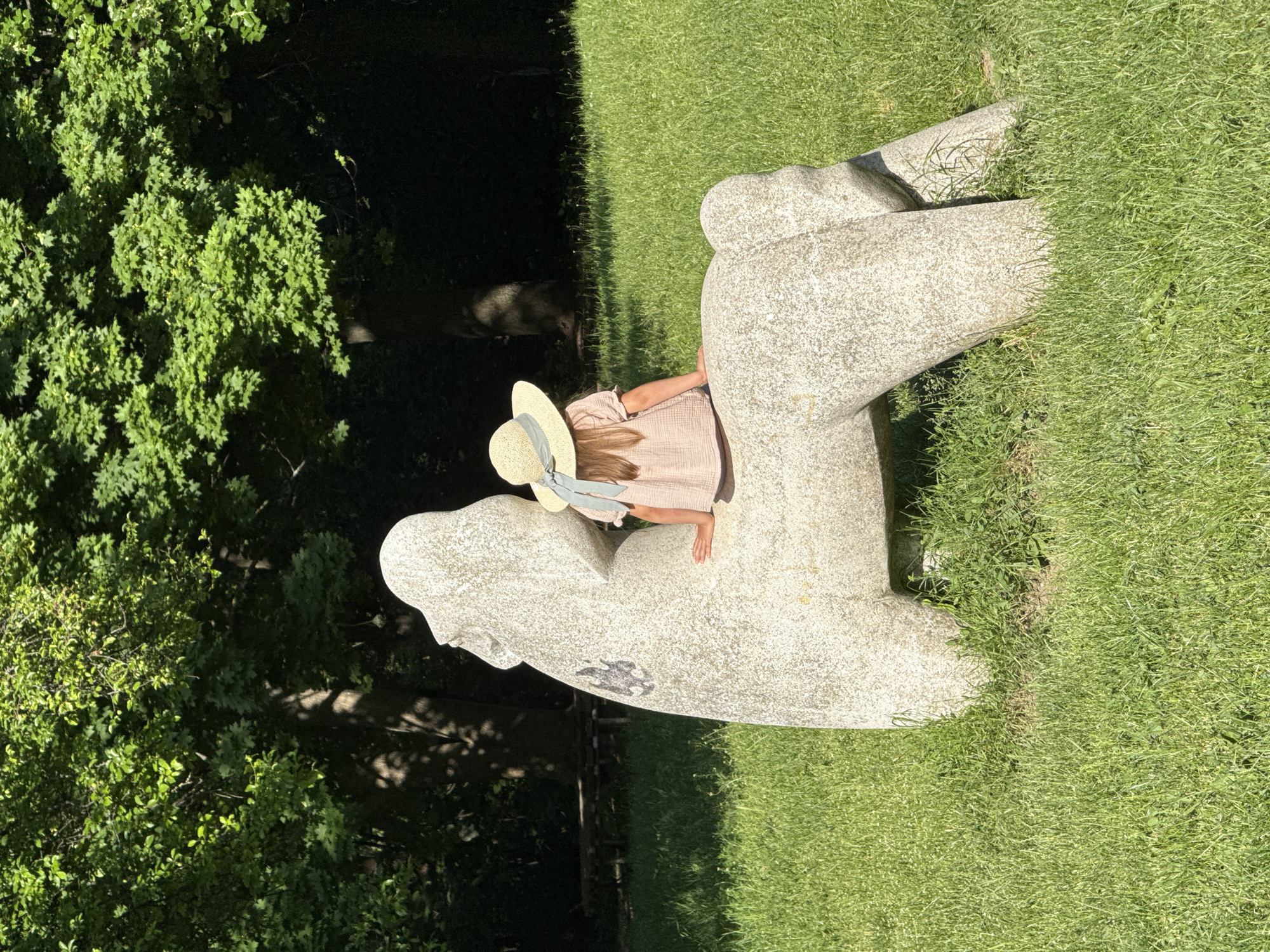 Children play near stone sculpture in Sofia park