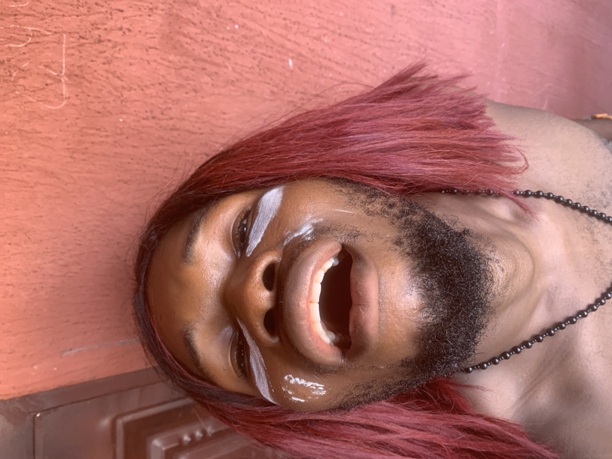 Person with pink hair photographs selfies in Nkpor, Nigeria