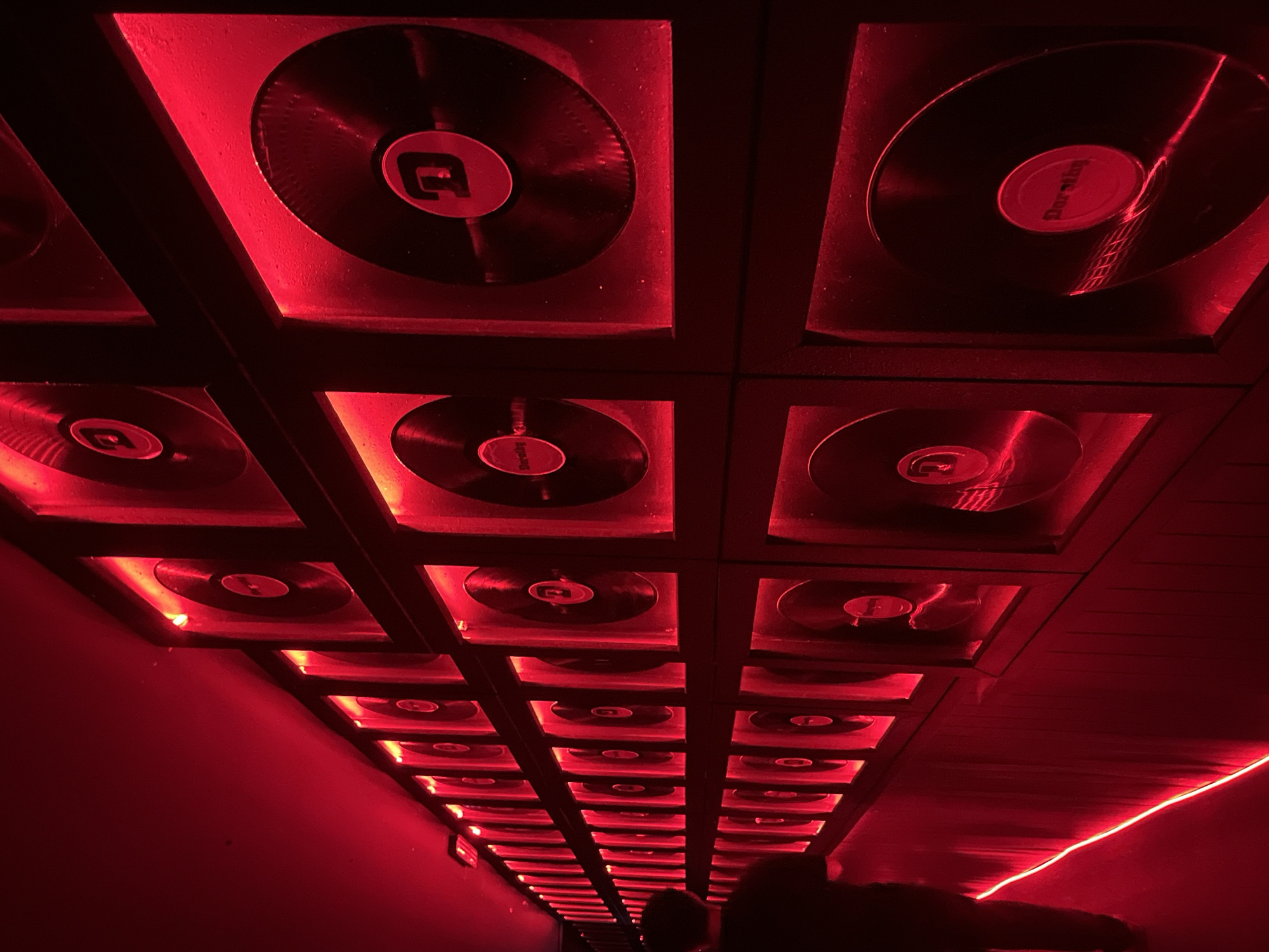 Illuminated vinyl record display documented in club-like venue