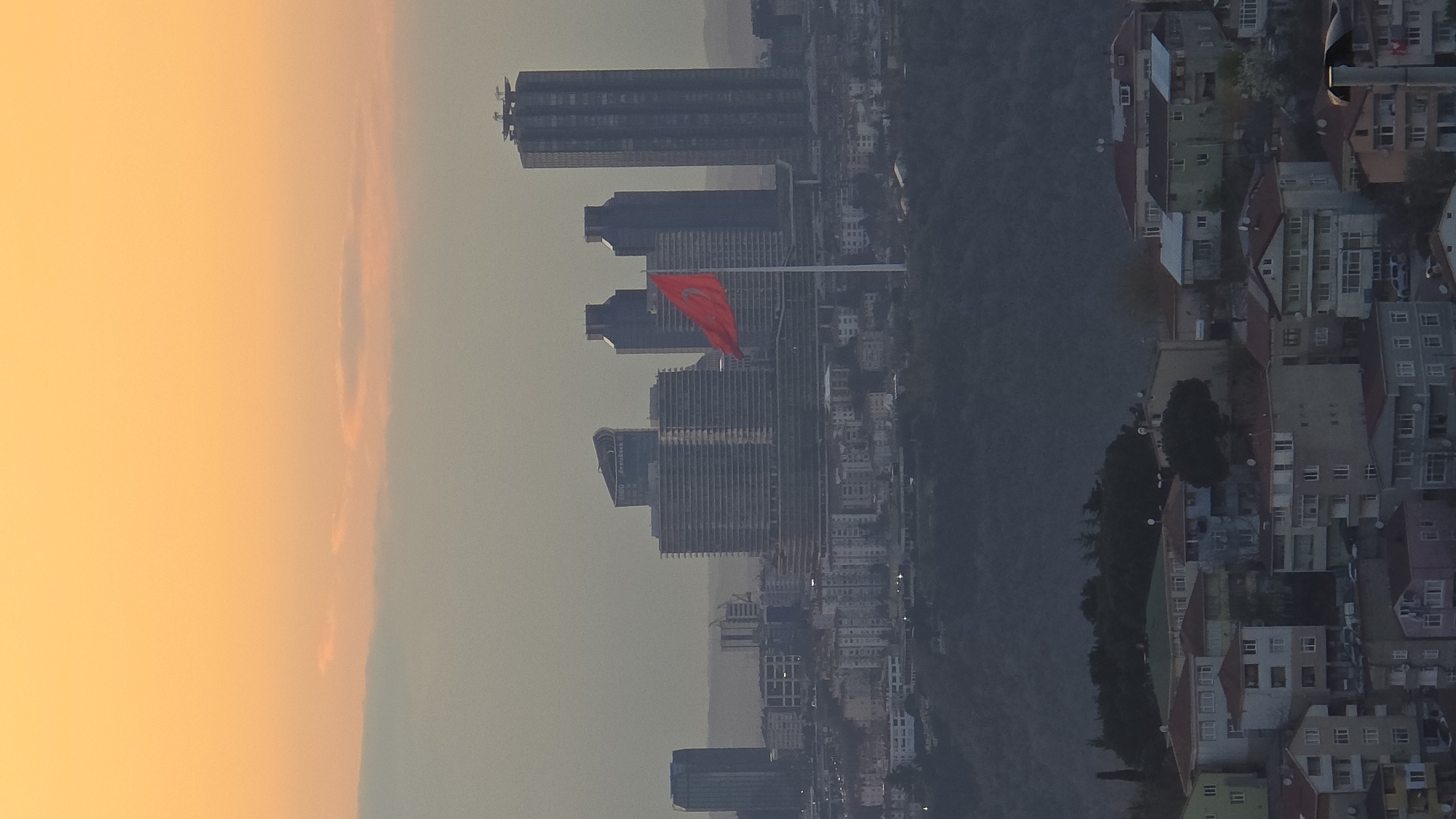Turkish flag prominently displayed over Üsküdar skyline at dusk