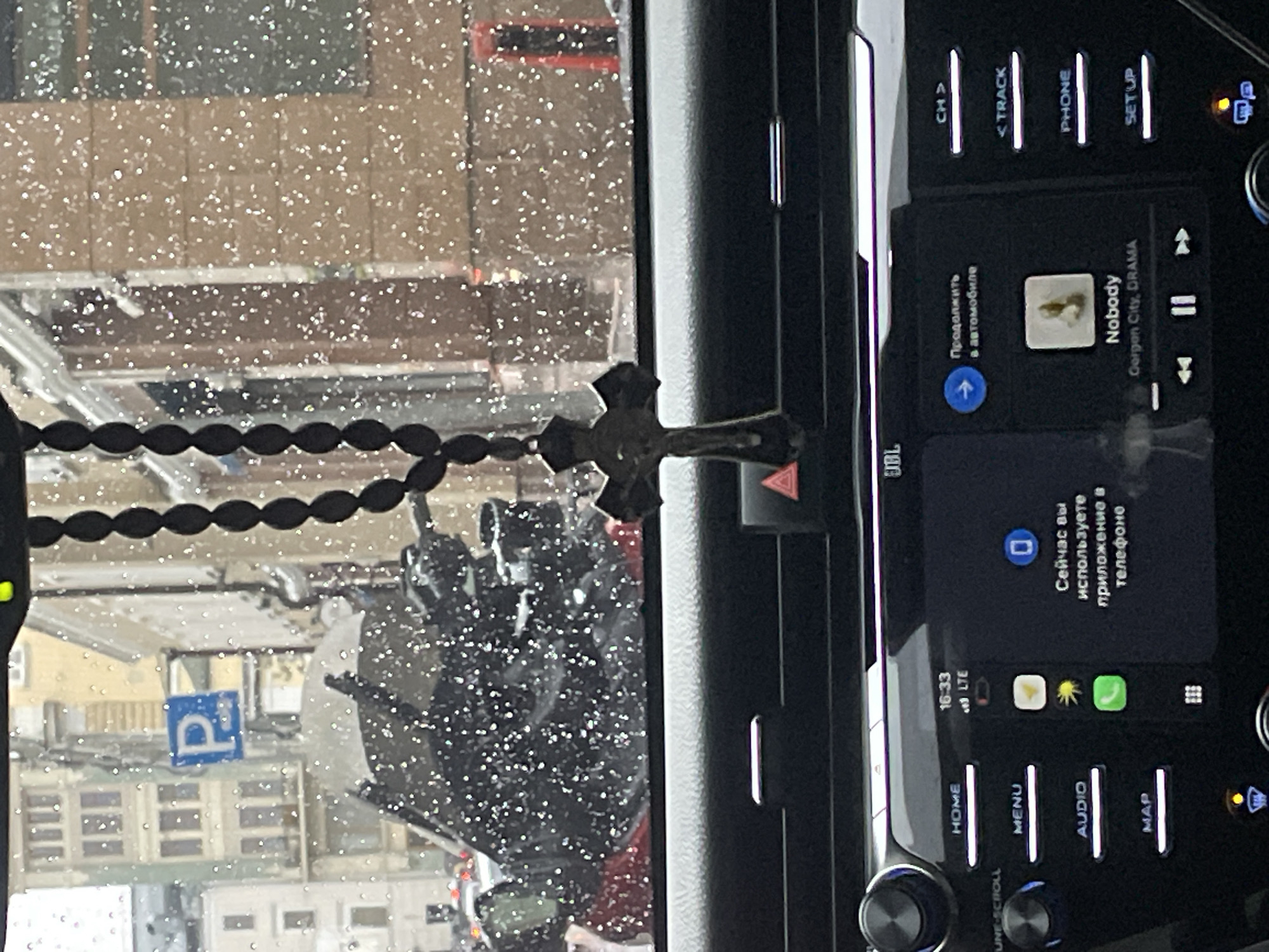 Vehicle interior documented with rosary hanging from dashboard