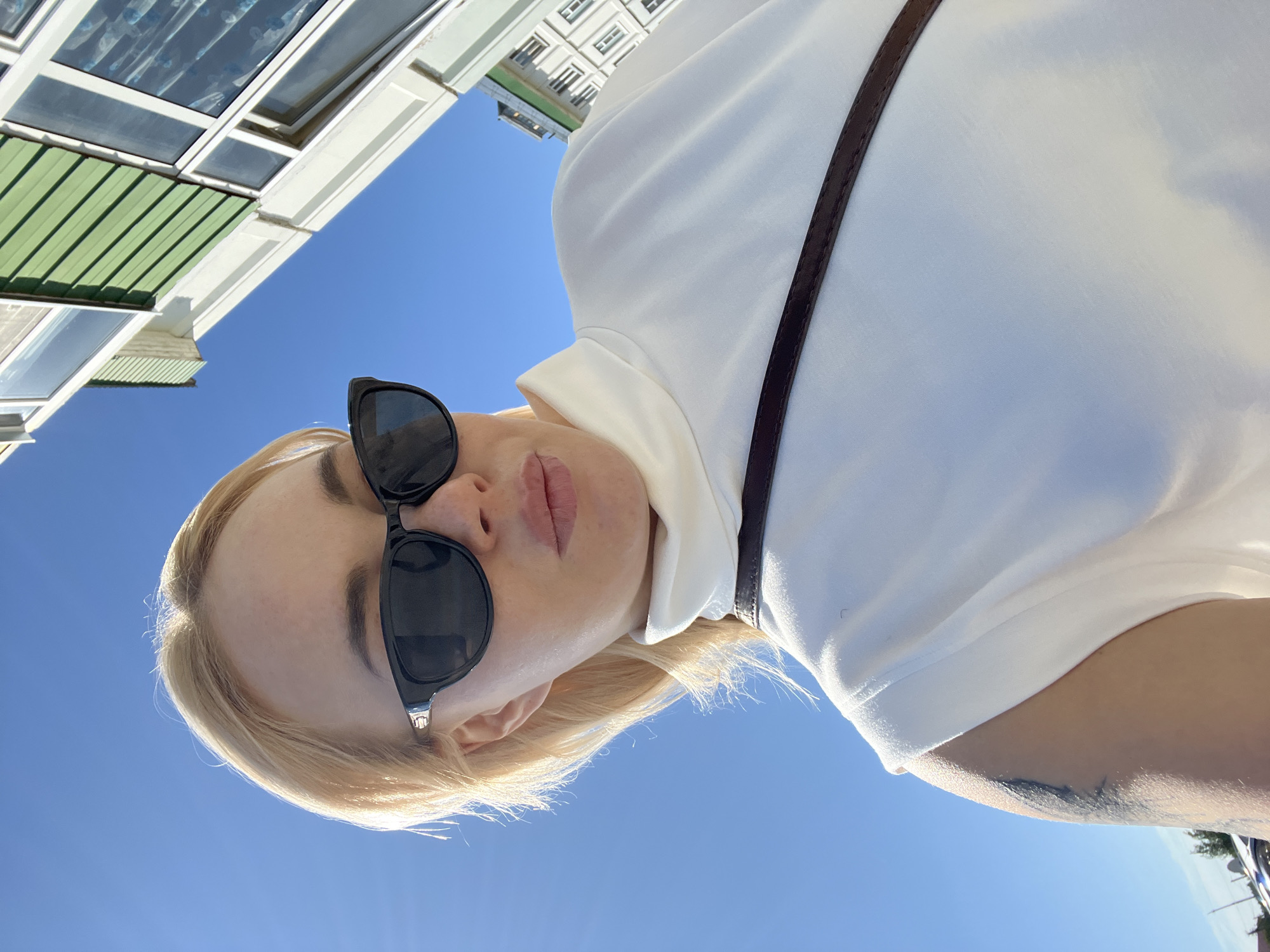 Sunny day selfie series outside a light blue building