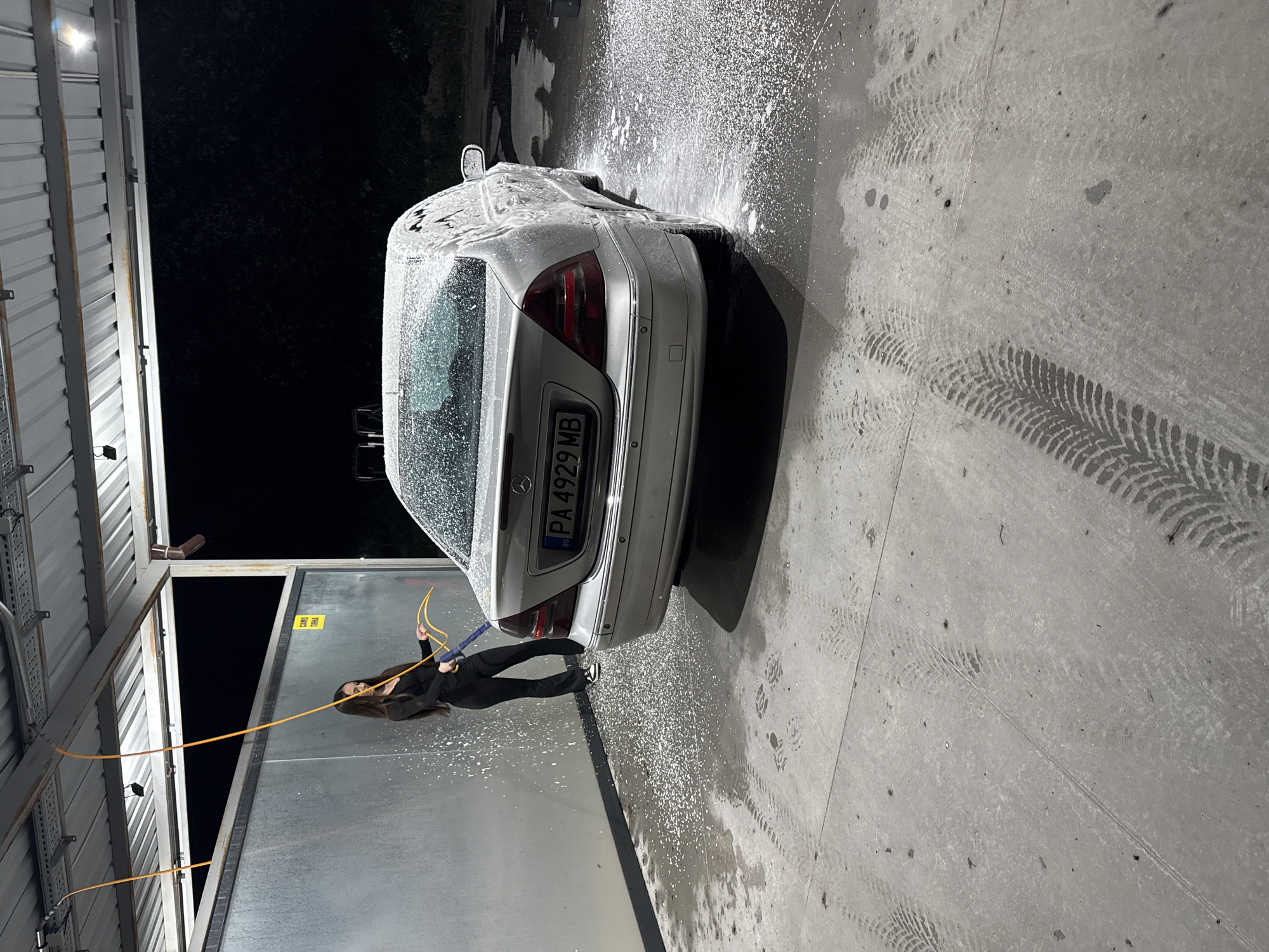 Woman washes silver Mercedes at car wash in Plovdiv