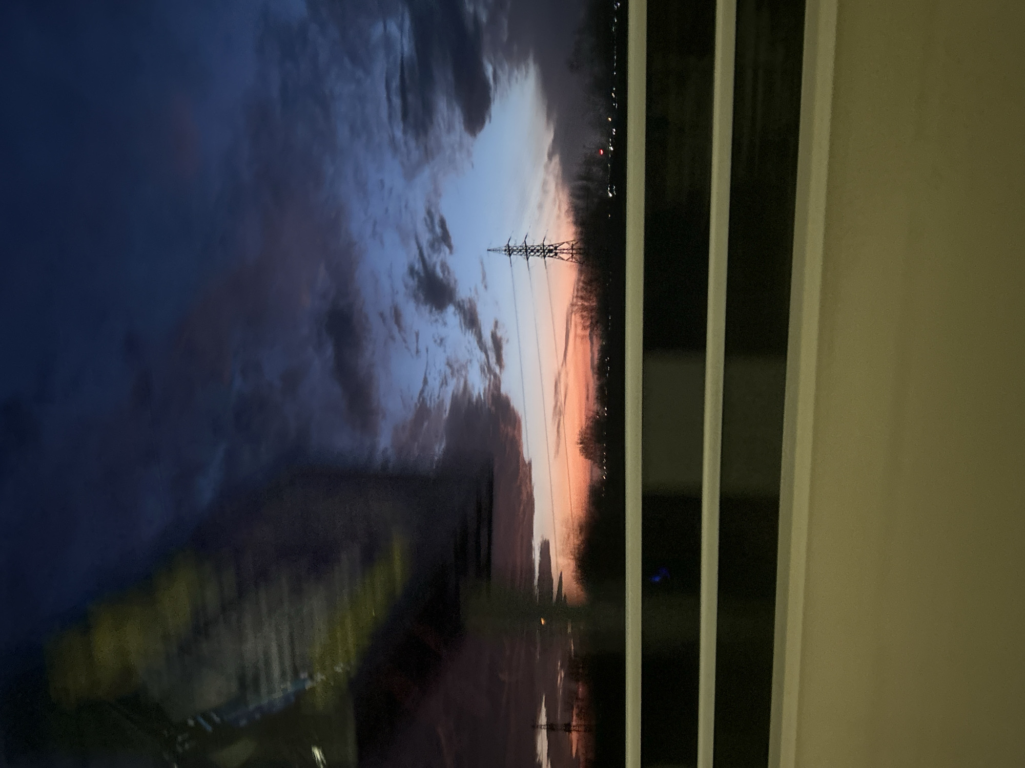 Sunset power lines photographed through blinds in Burgas