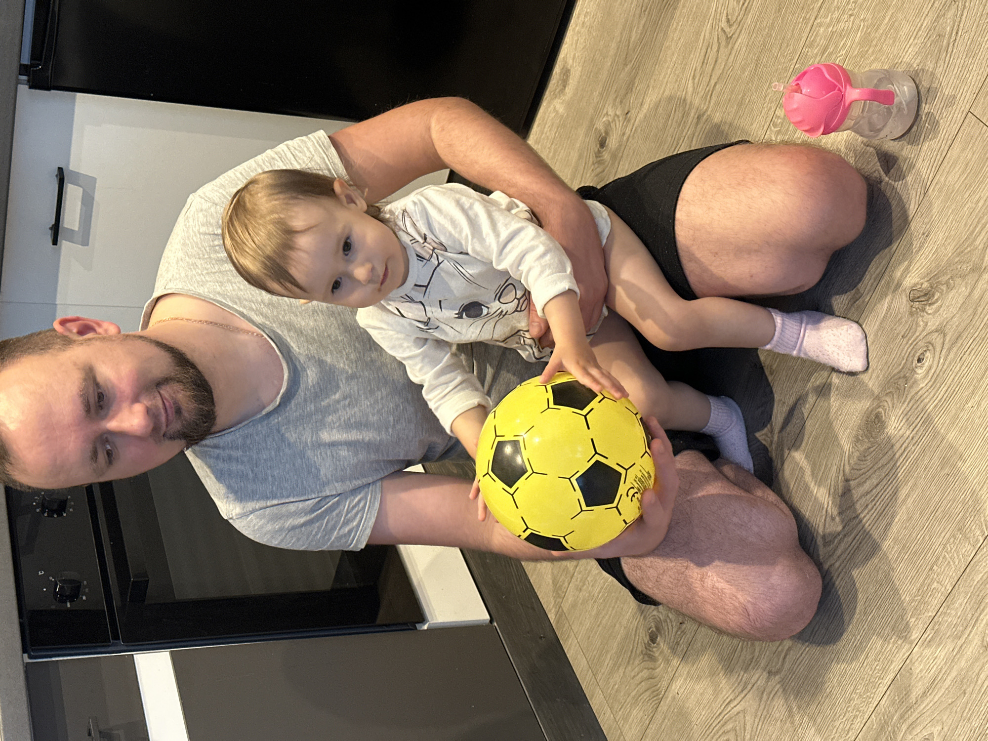 Father and child share quiet moment on floor in Wisła