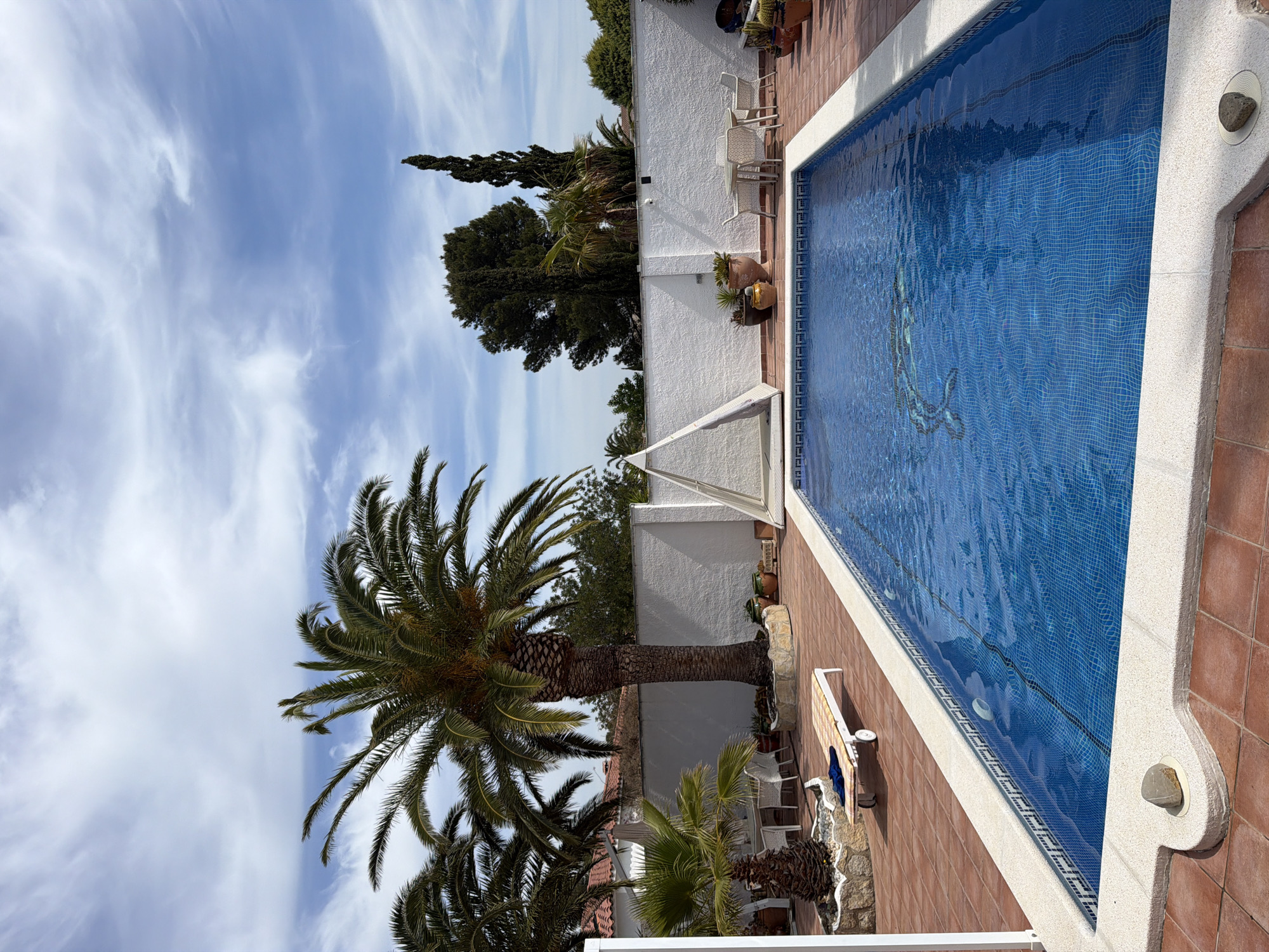 Man examines pool drain in Mont-roig del Camp courtyard