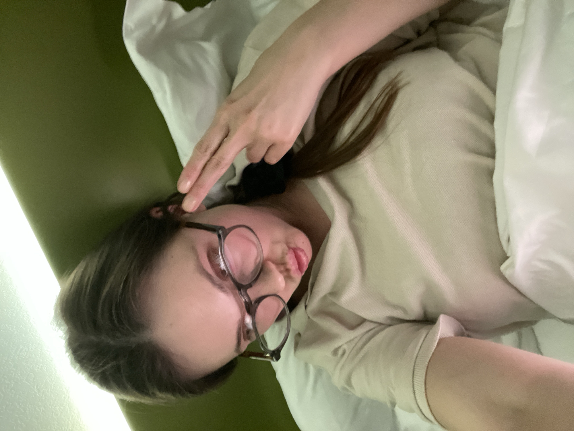 Woman makes peace sign while lying in bed in Venice