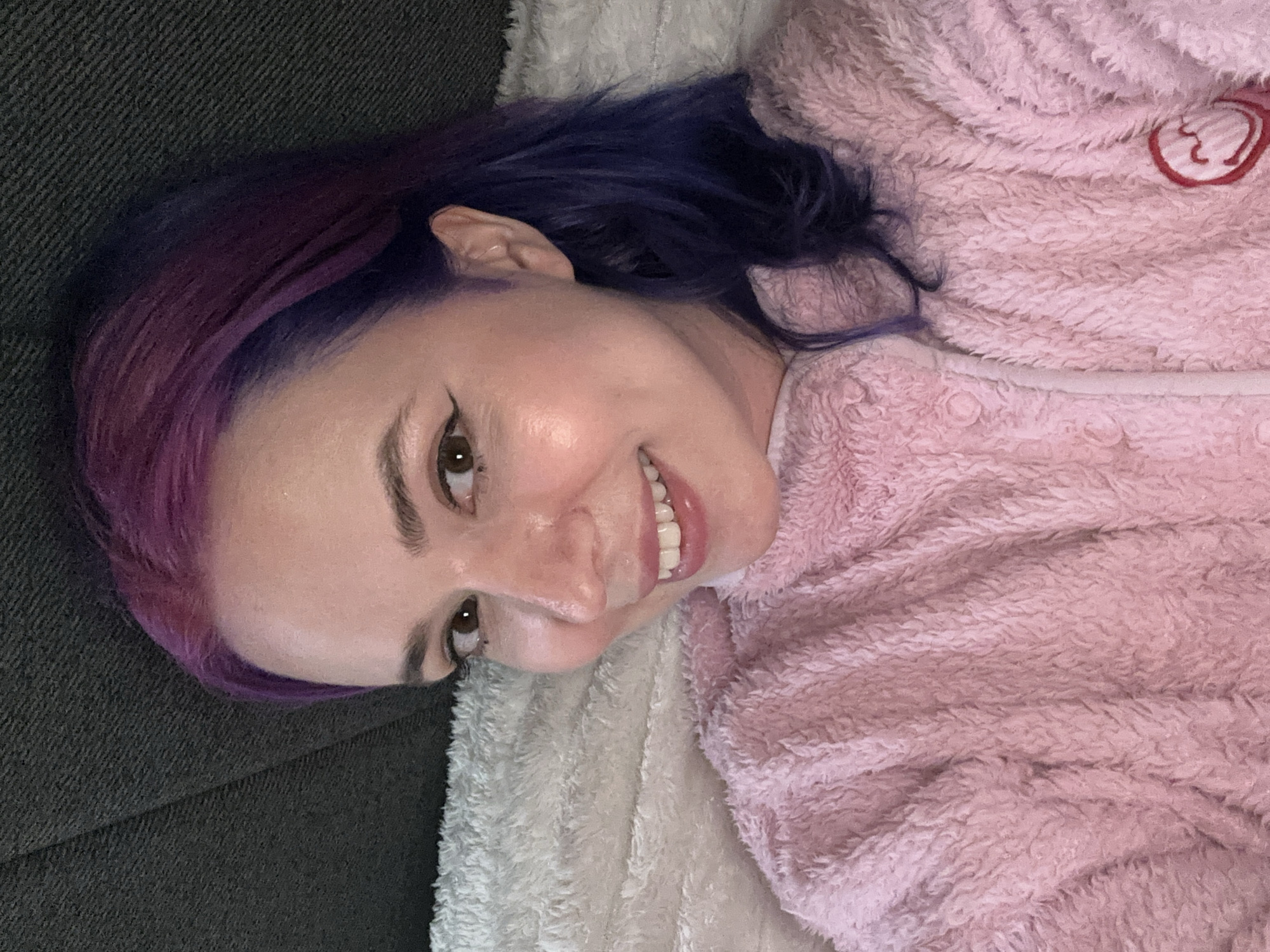 Woman in pink robe rests on couch in Zagreb