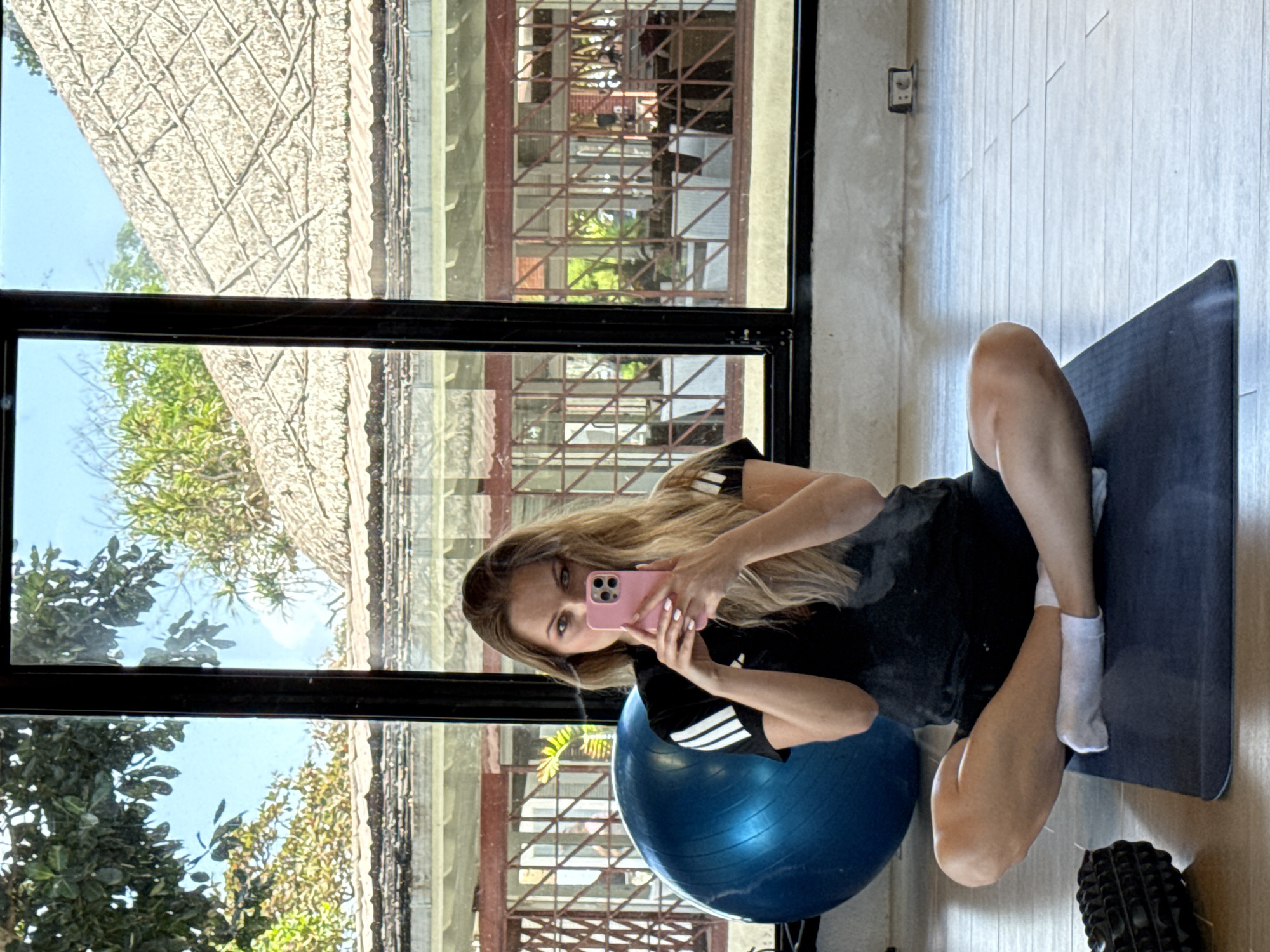 Selfie session in a Bali fitness studio, yoga mat and mirror.