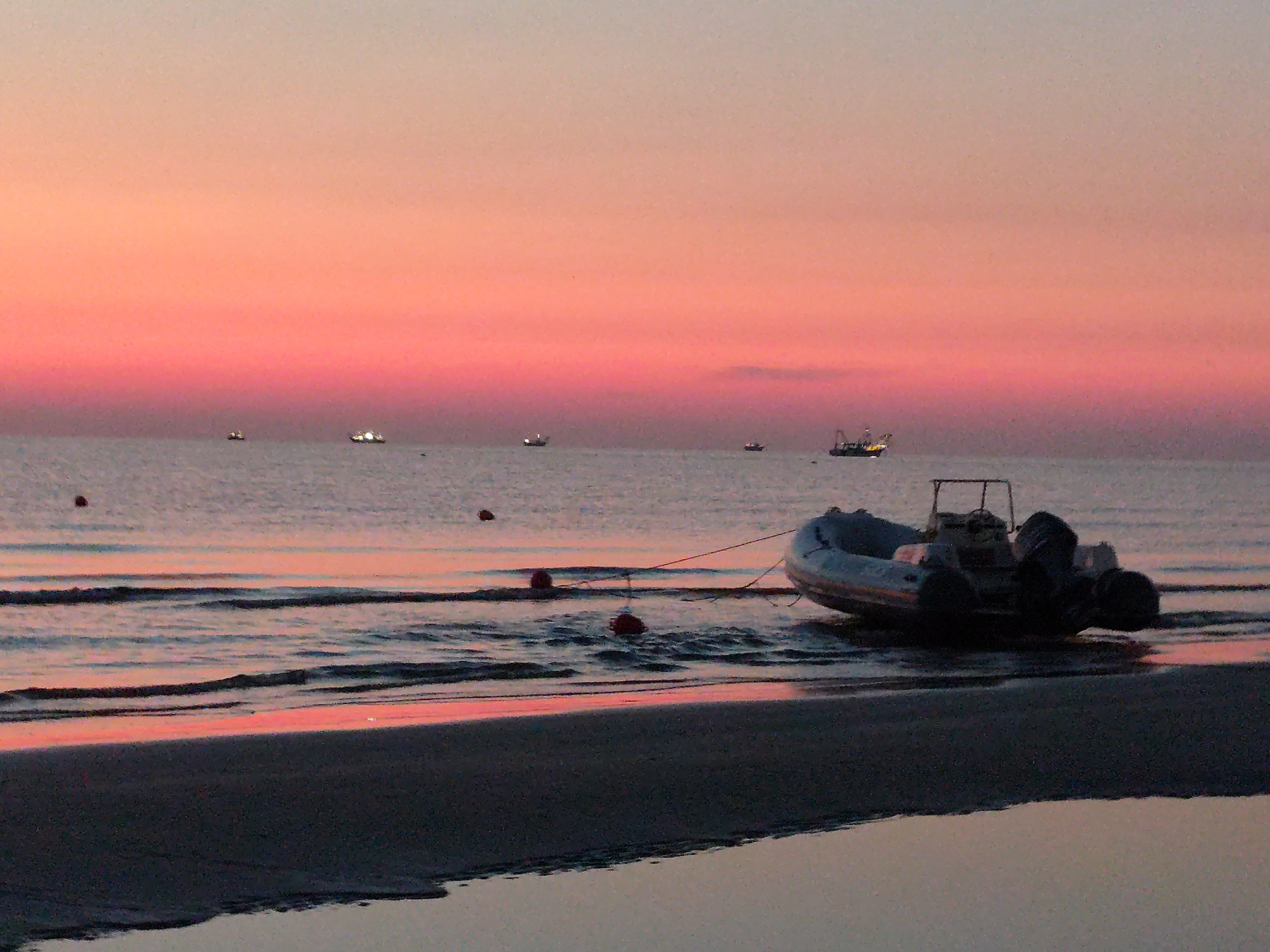 Rimini beach at golden hour, boat on shore