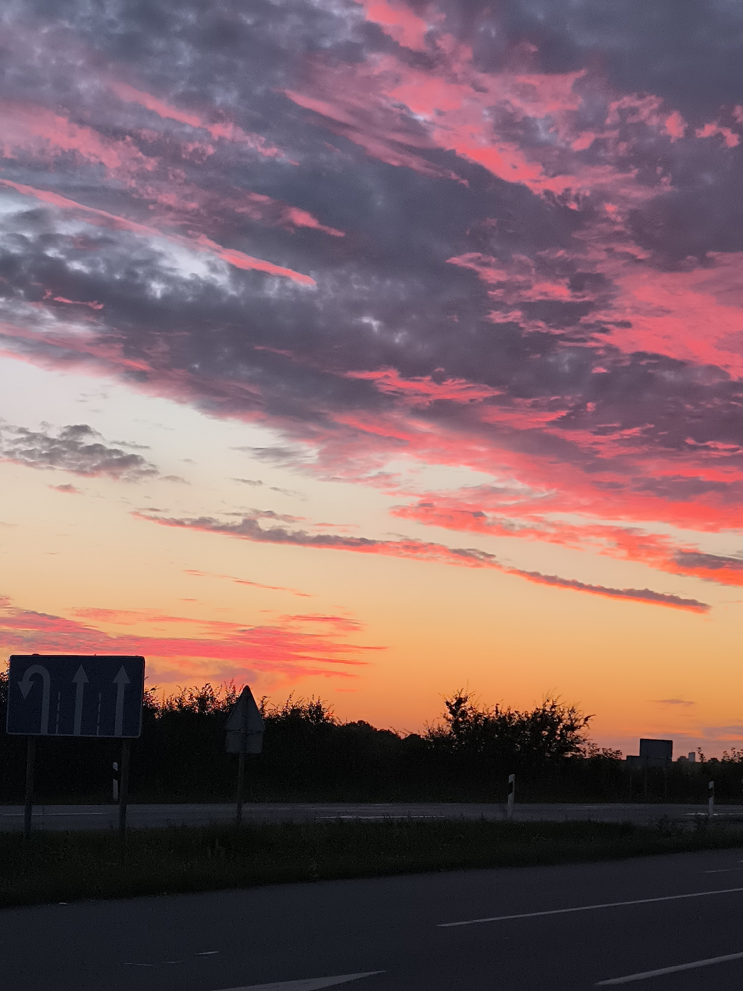 Sunset clouds over a Lithuanian highway in Dumpiai
