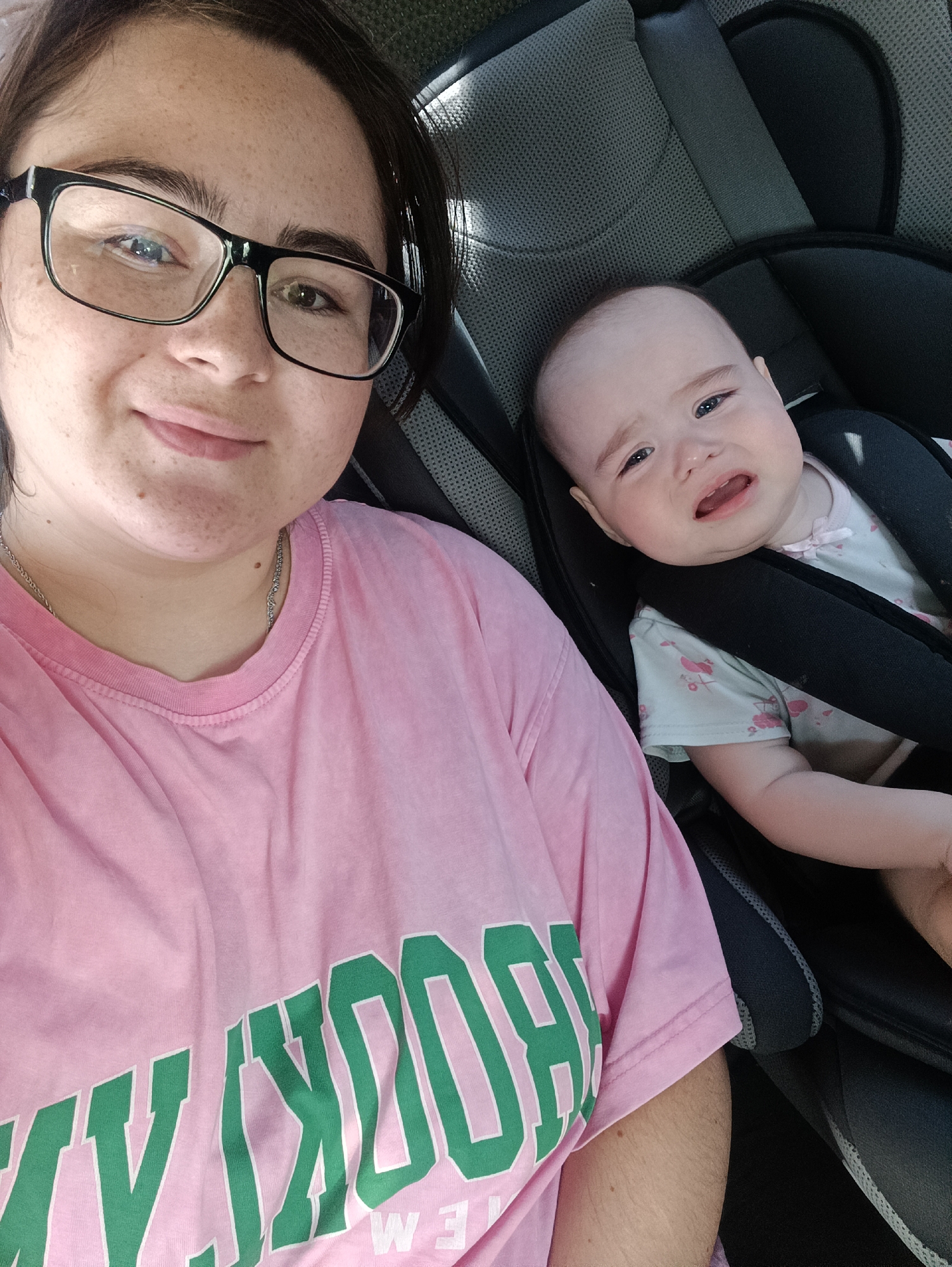 Smiling driver and crying baby in a car seat, Russia