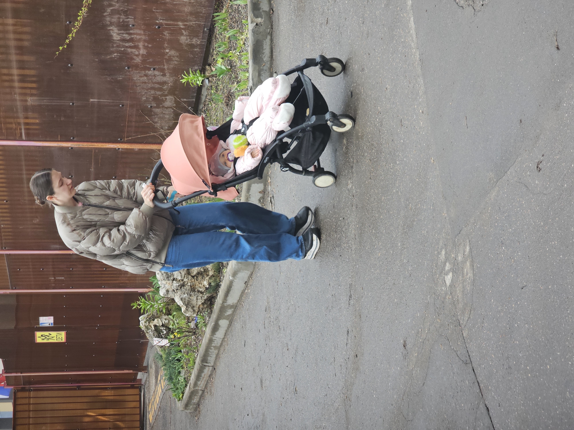 Morning pedestrians navigate wet Moscow streets with stroller, backpack