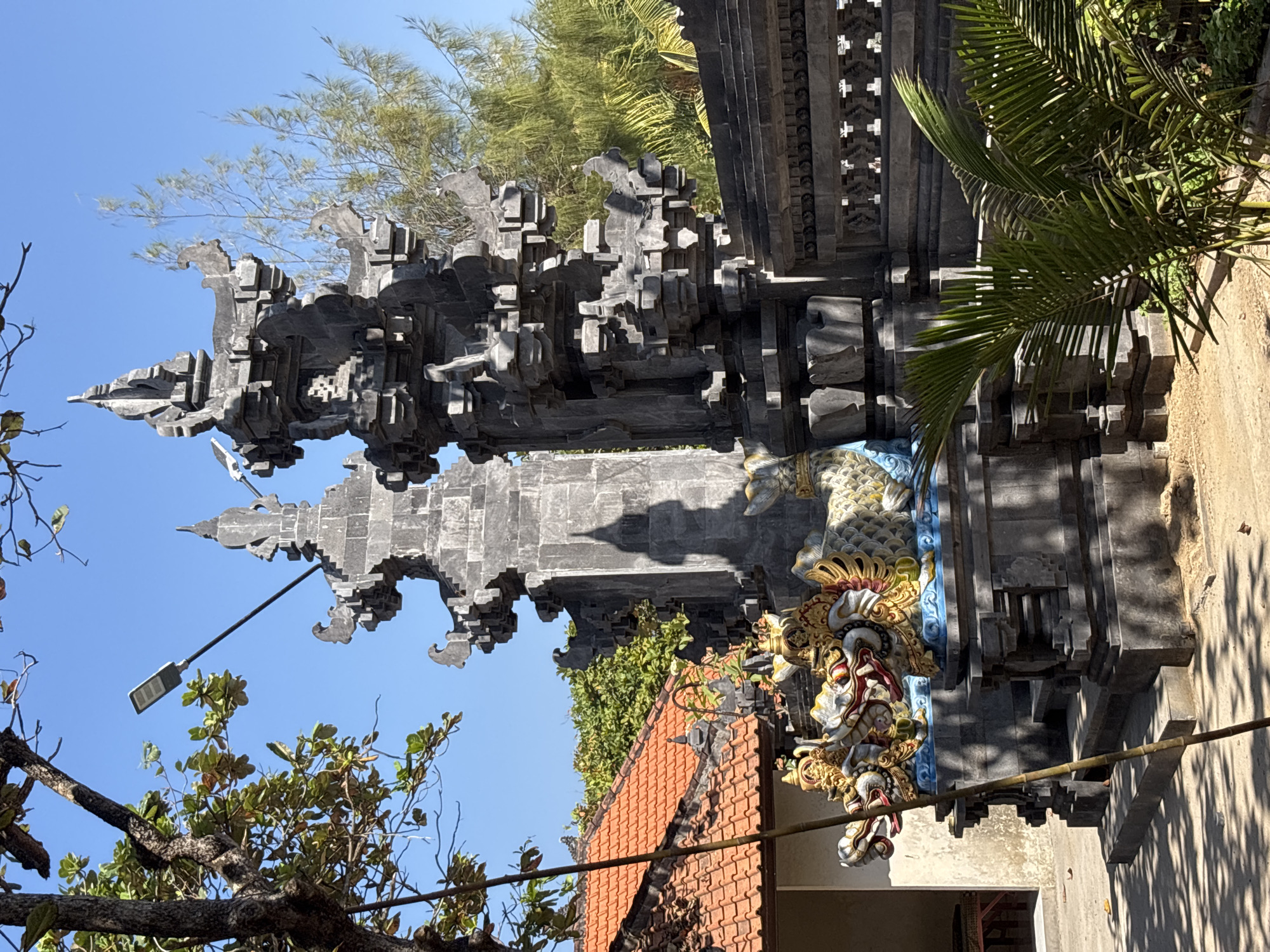 South Bali beachfront life around a carved Balinese gateway