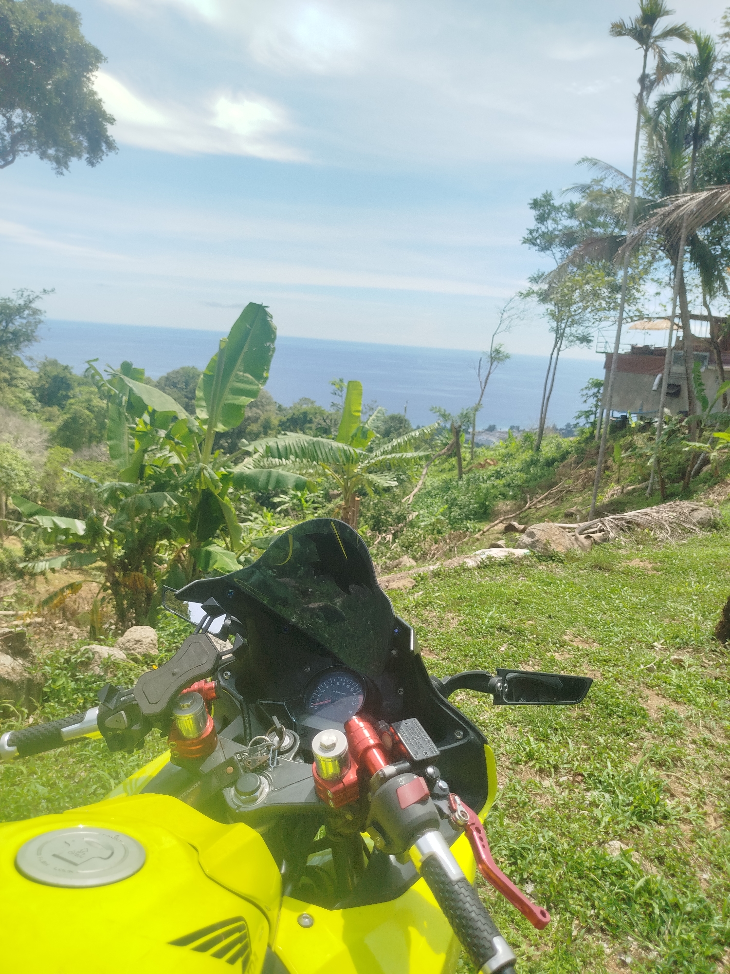 Parked motorcycle, ocean views from a Karon hillside