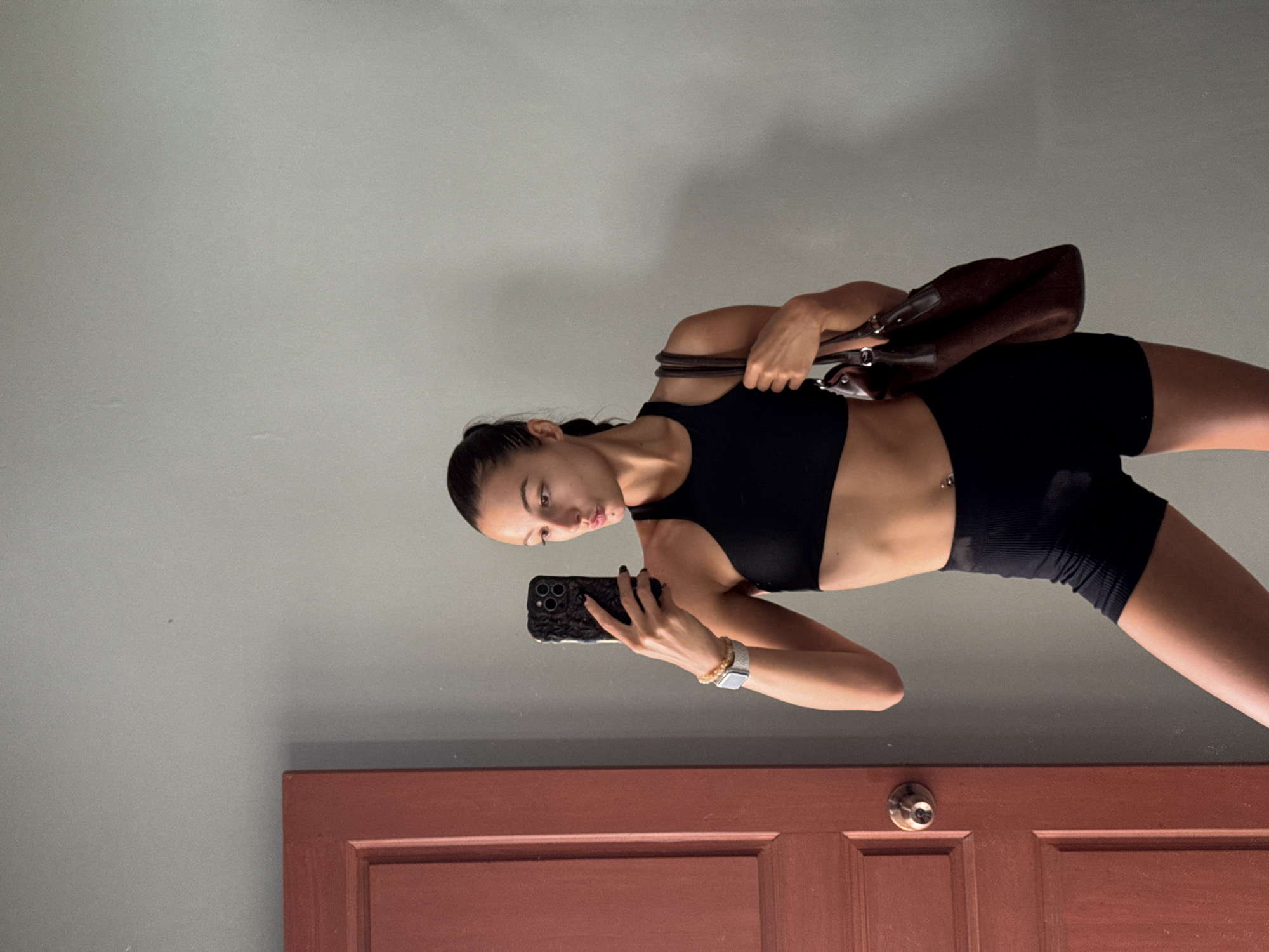 Woman Takes Mirror Selfies in Black Workout Gear in Thailand