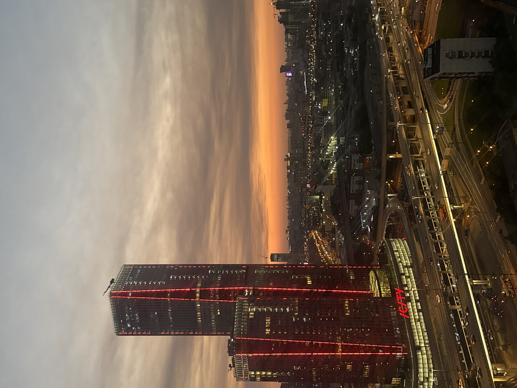 City skyline at dusk, twin skyscrapers under a warm clouded sky