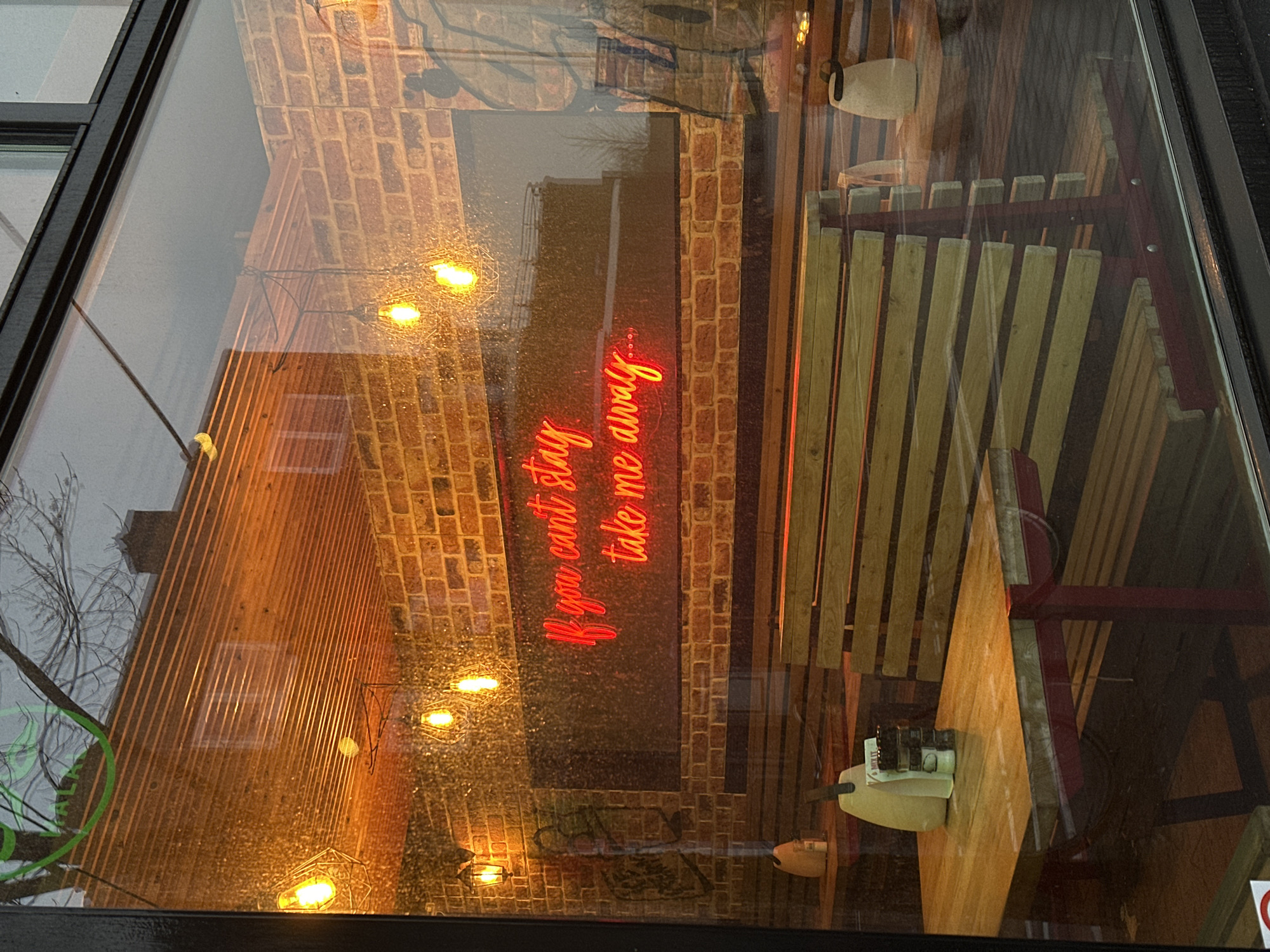 Window reflection captures Amsterdam building details with string lights