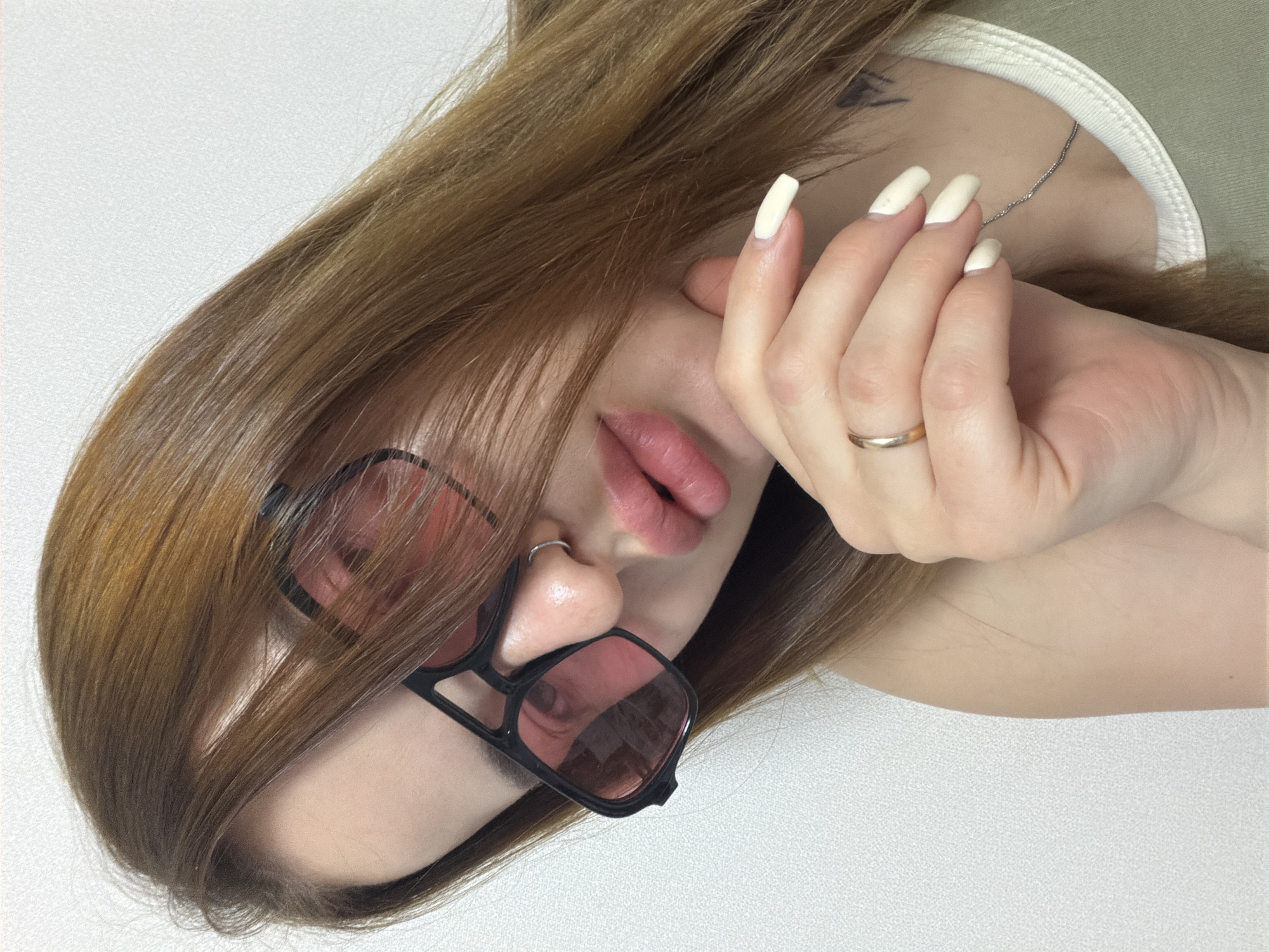 Person with tilted head, hand covering face captured close-up