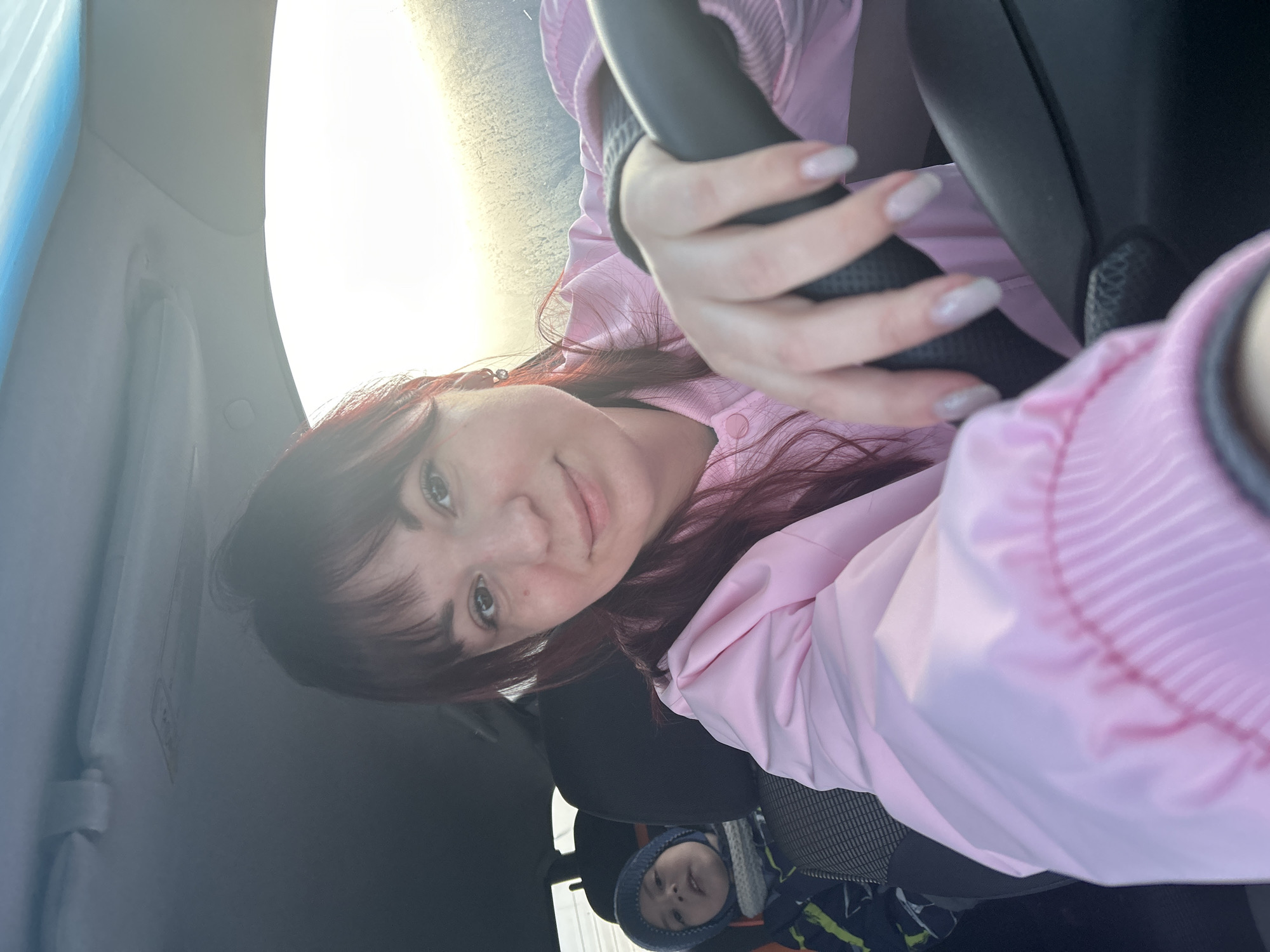 Woman takes car selfies with sleeping child during sunset