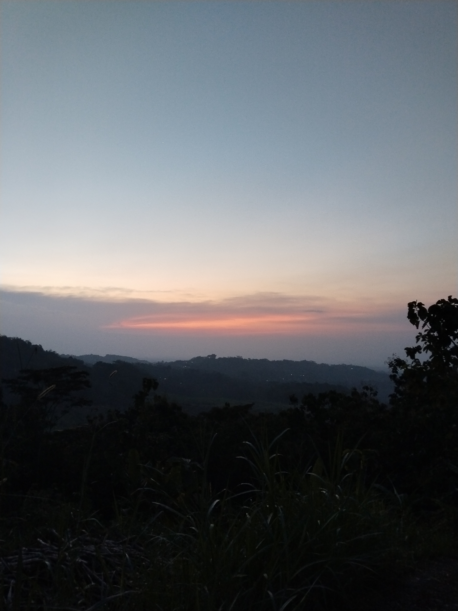 Person captured shouting against twilight sky in landscape setting