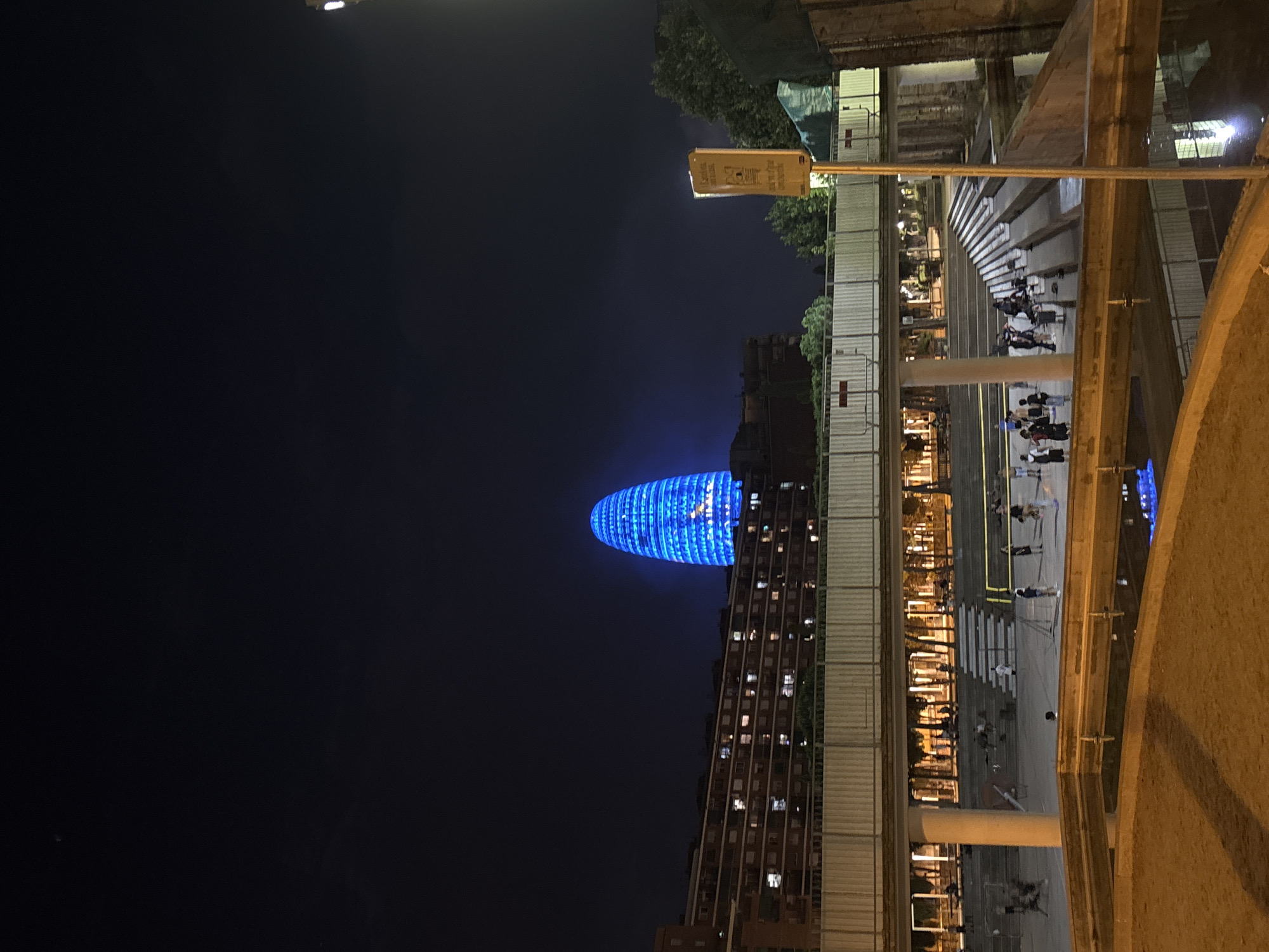 Torre Glòries glowing blue in the Barcelona night