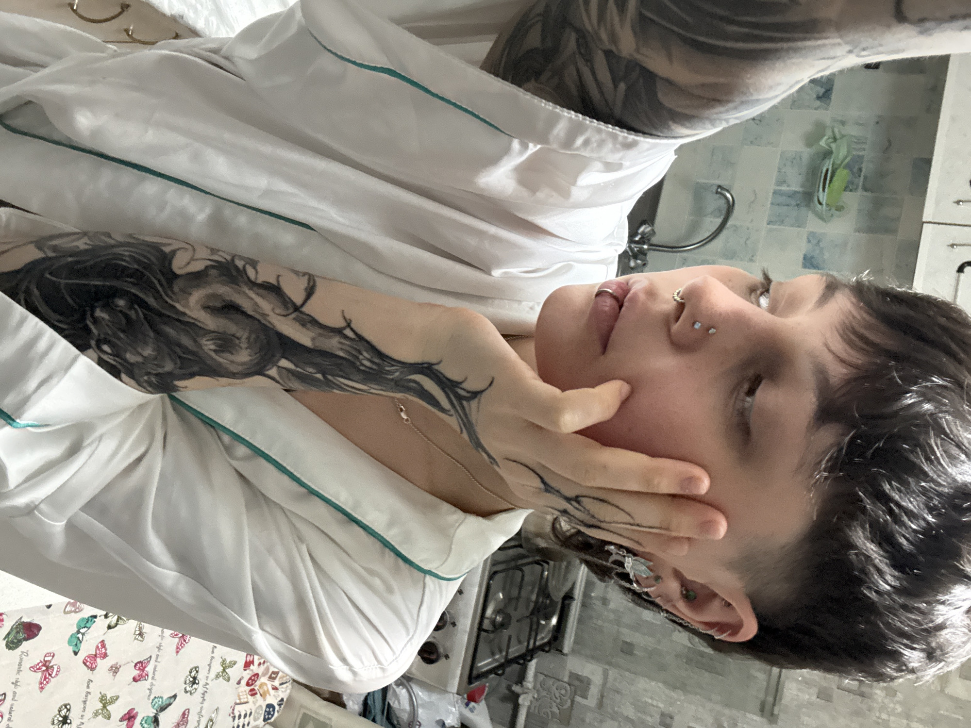 Tattooed individual photographed in white robe inside Saint Petersburg residence