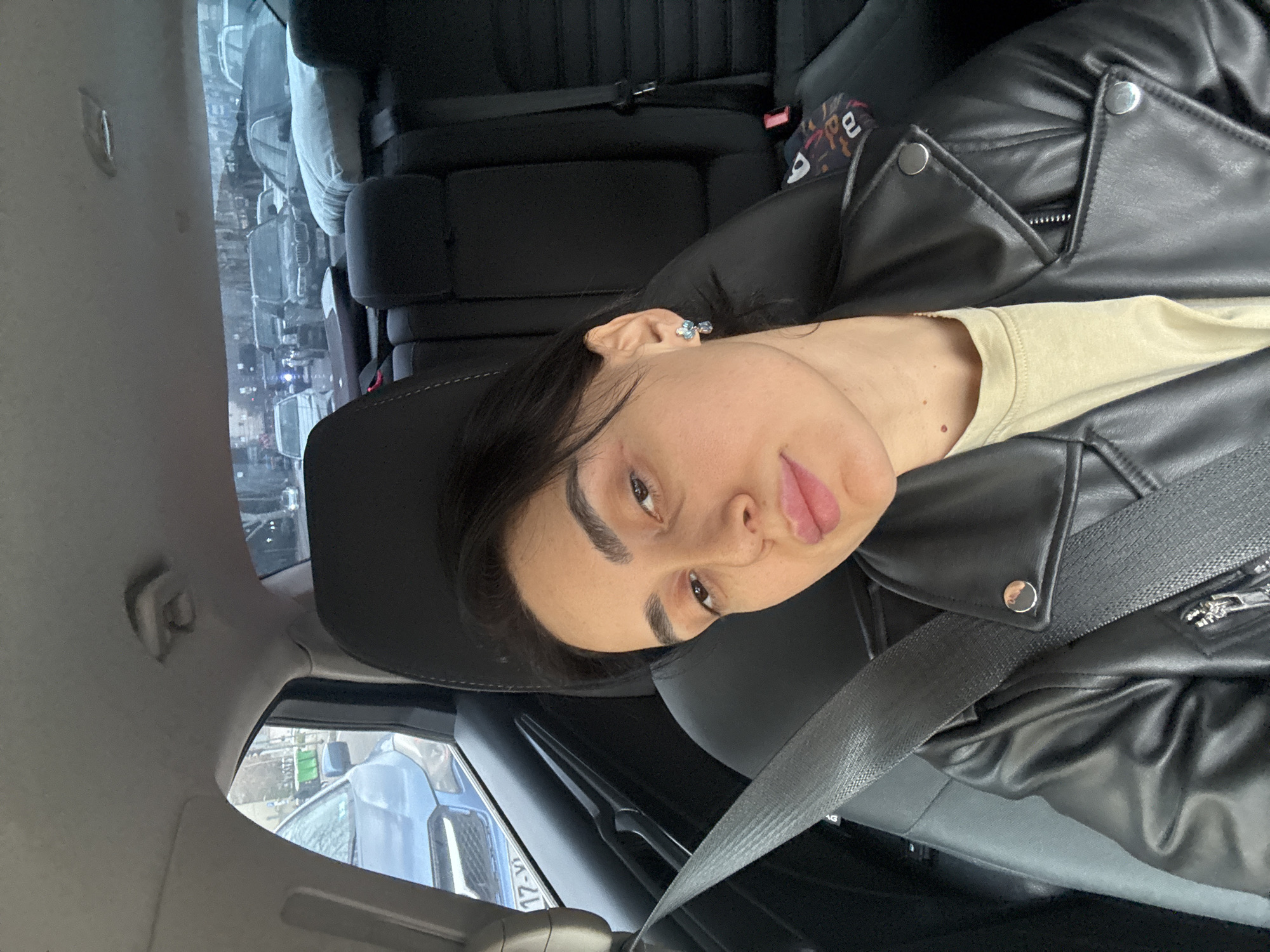 Woman takes selfie in passenger seat in Tbilisi