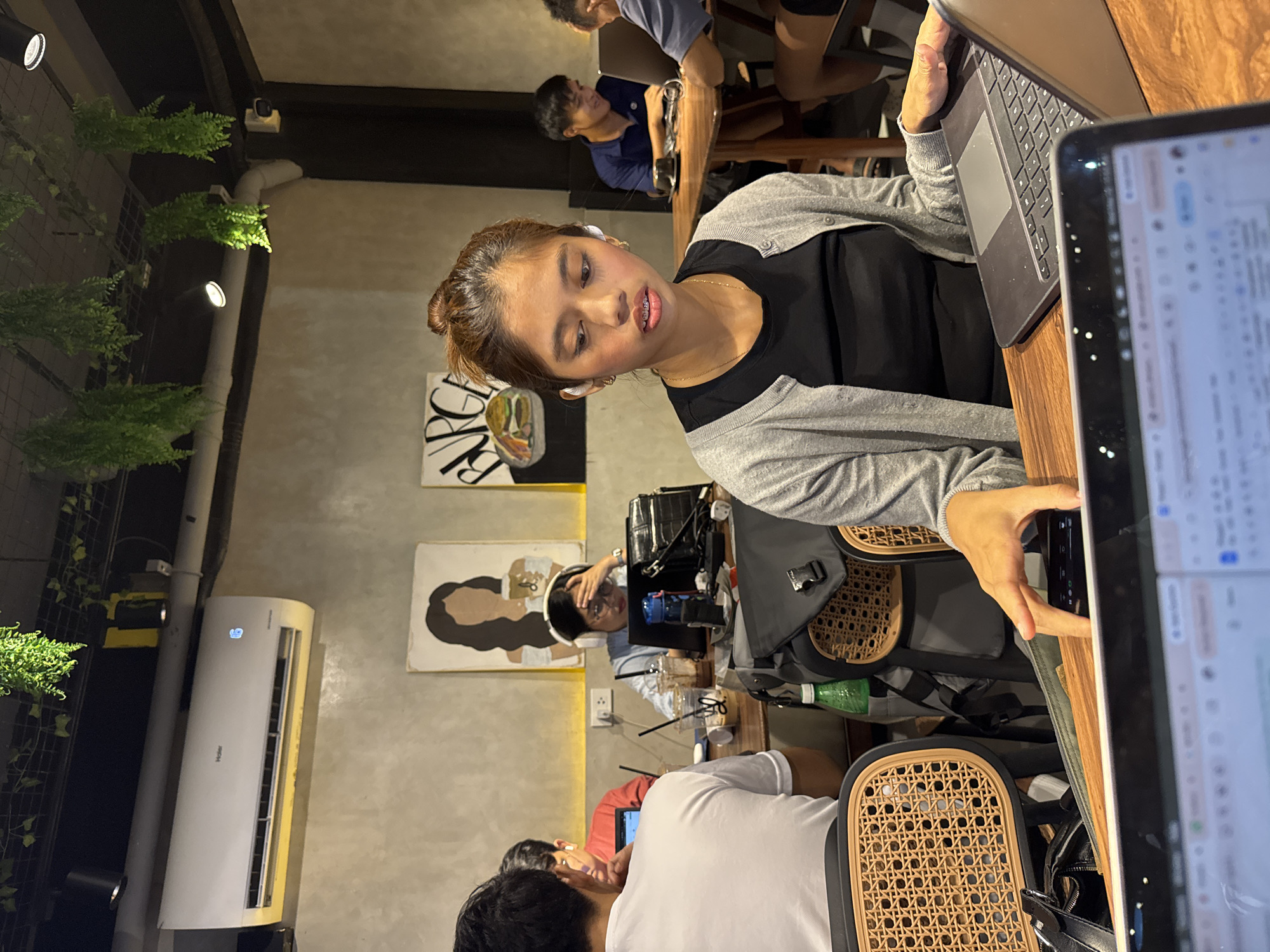 Woman works on laptop at busy Davao City café