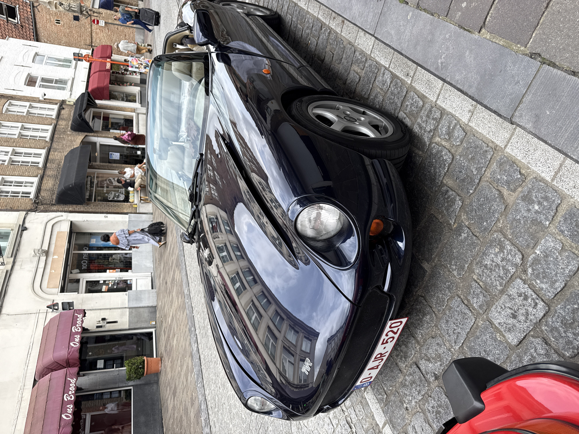 Classic sports cars parked on cobblestones in central Bruges