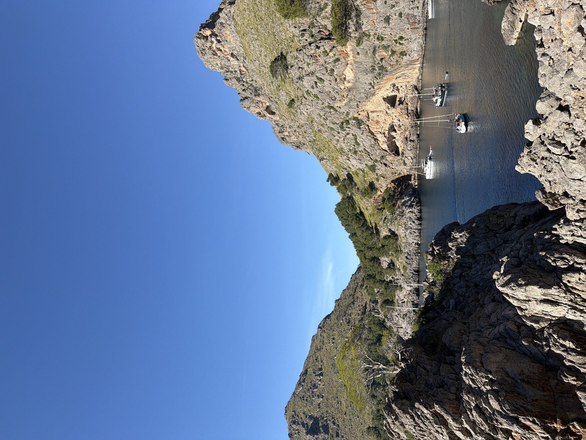 Tourist documents scenic Mediterranean cove views in Escorca, Spain