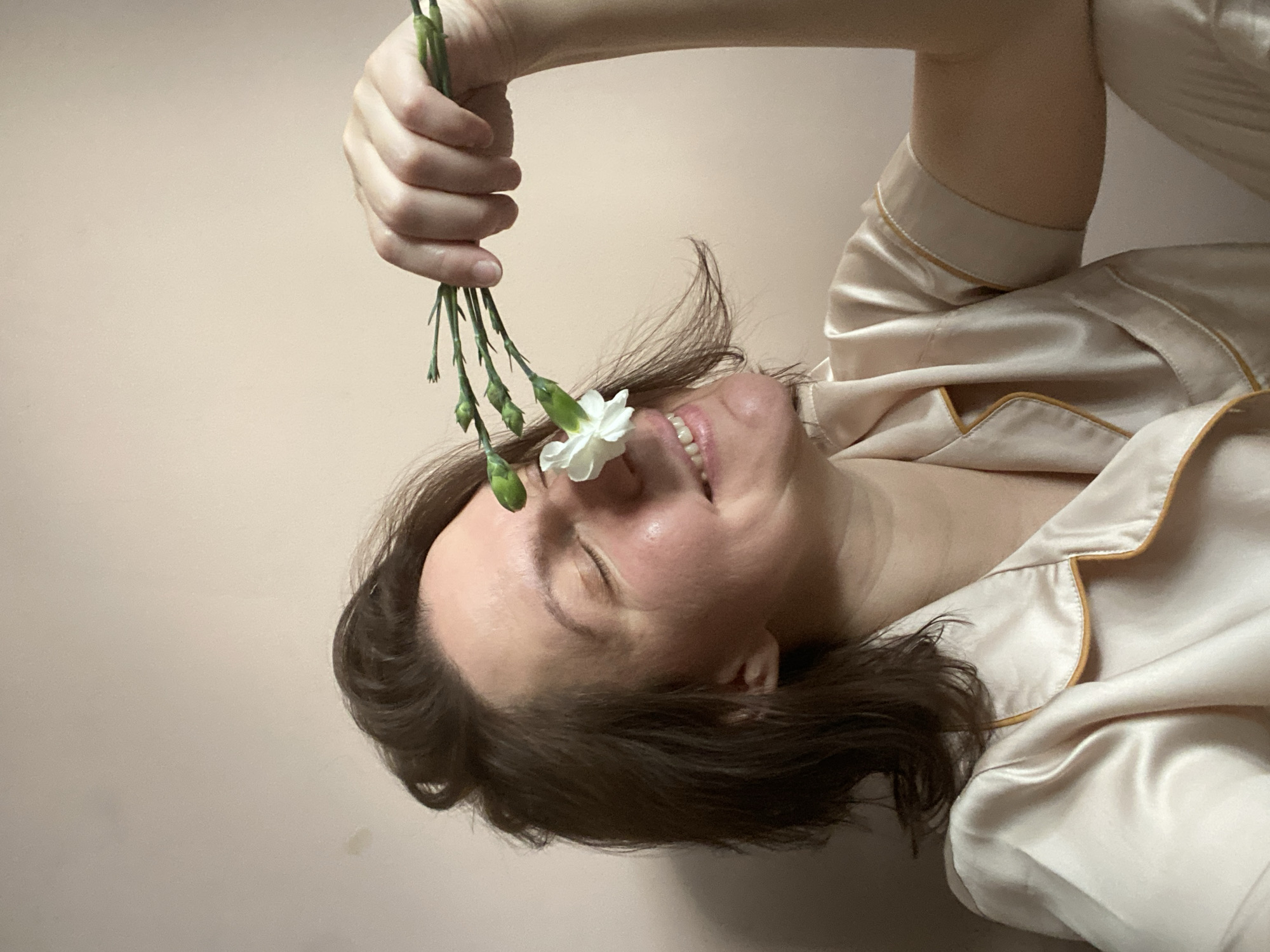 Woman photographs herself with white flowers in Chaikovsky