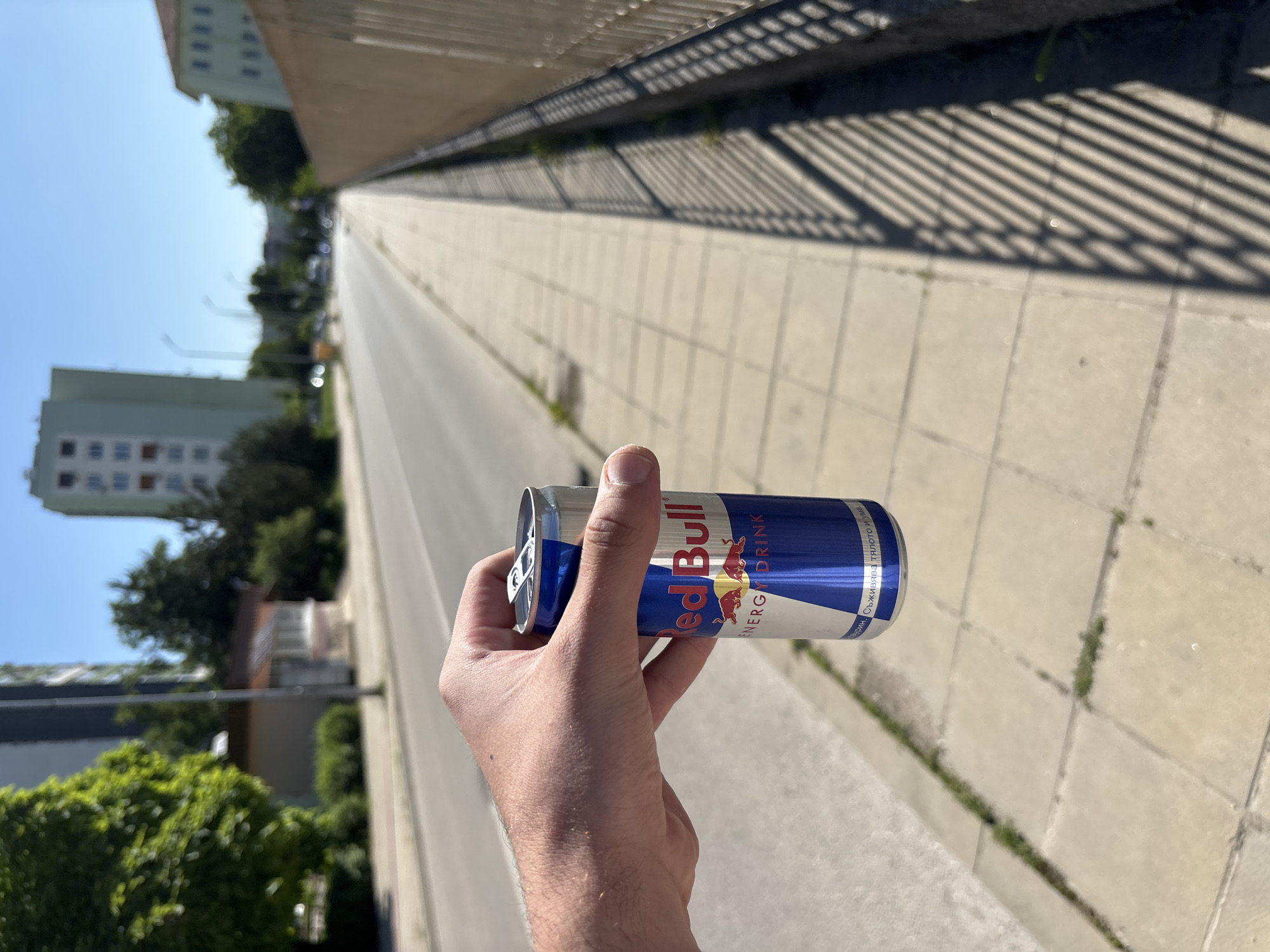 Person holds Red Bull can on Lovech street