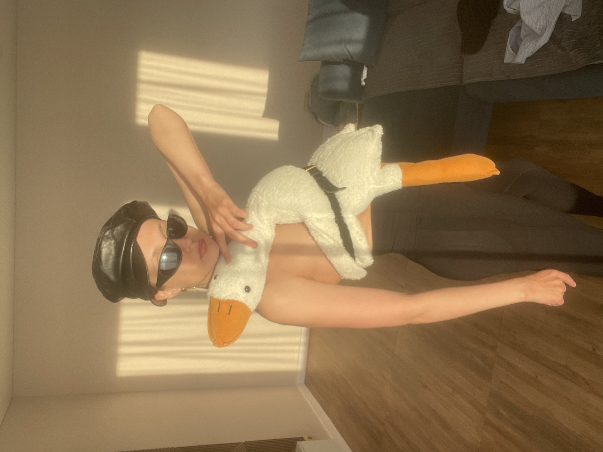 Person poses with giant plush goose in Russian home