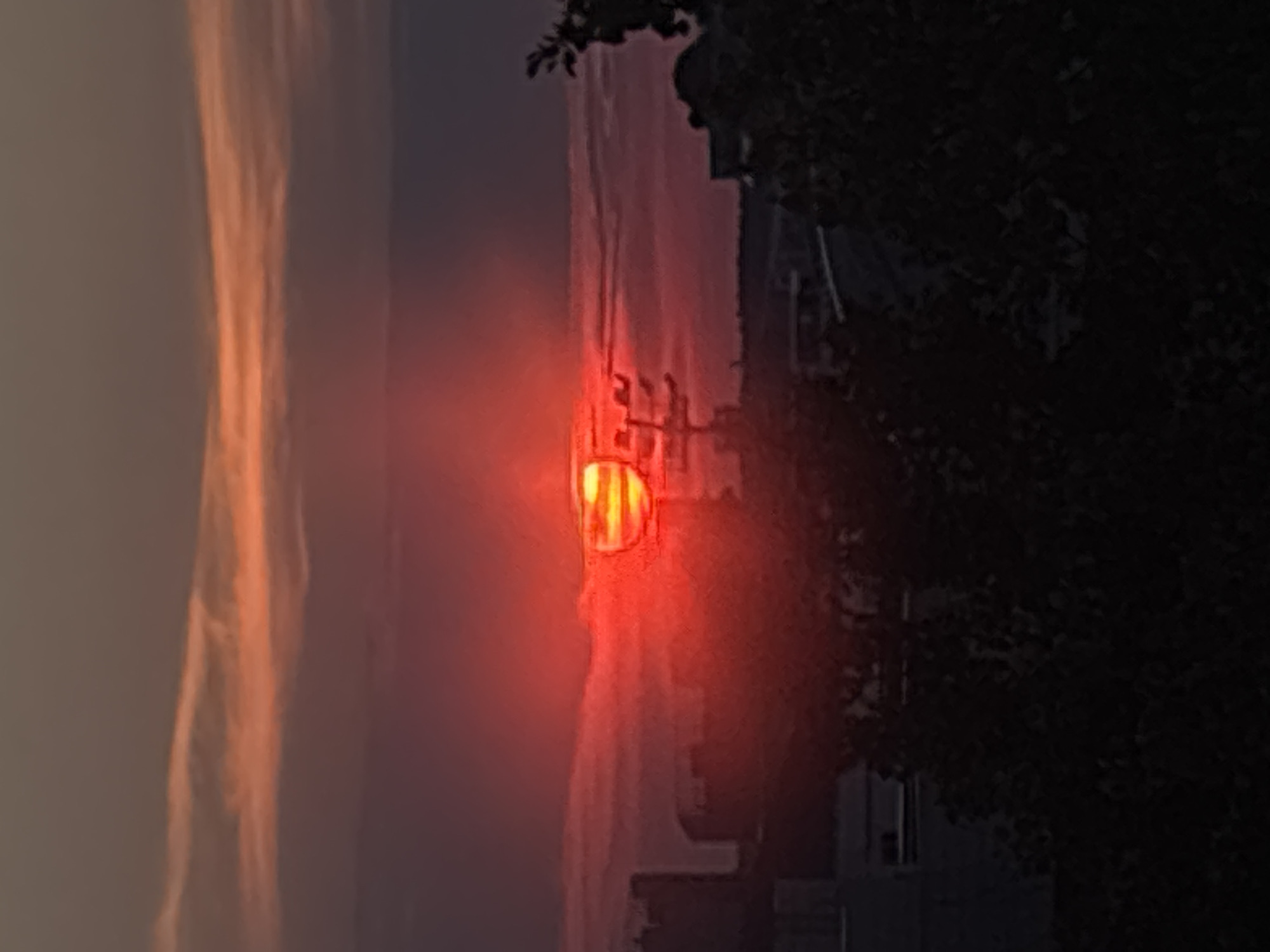 City skyline glows under a vivid orange and red sunset