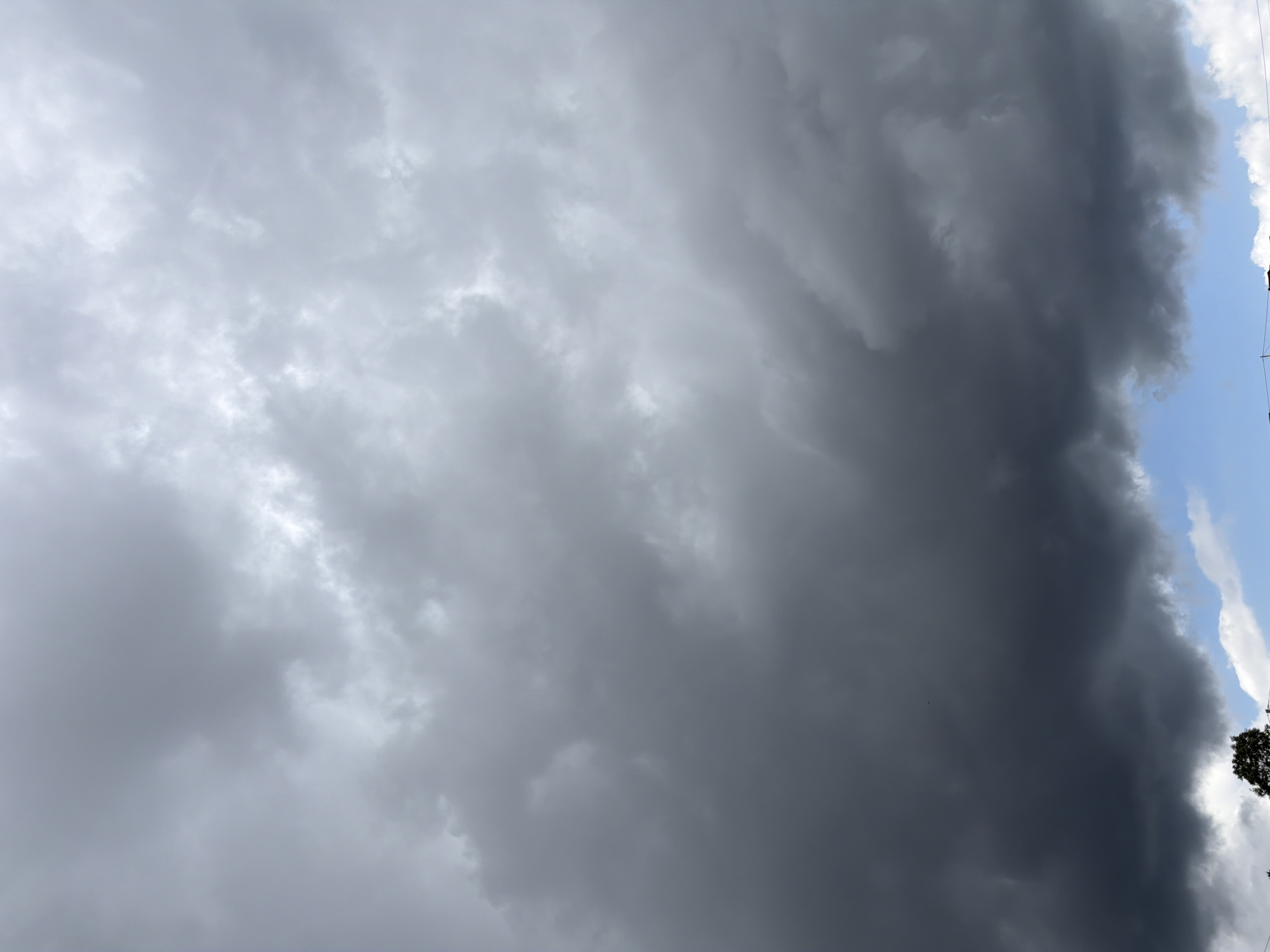 Crane work and storm clouds over a hillside village in southern Poland
