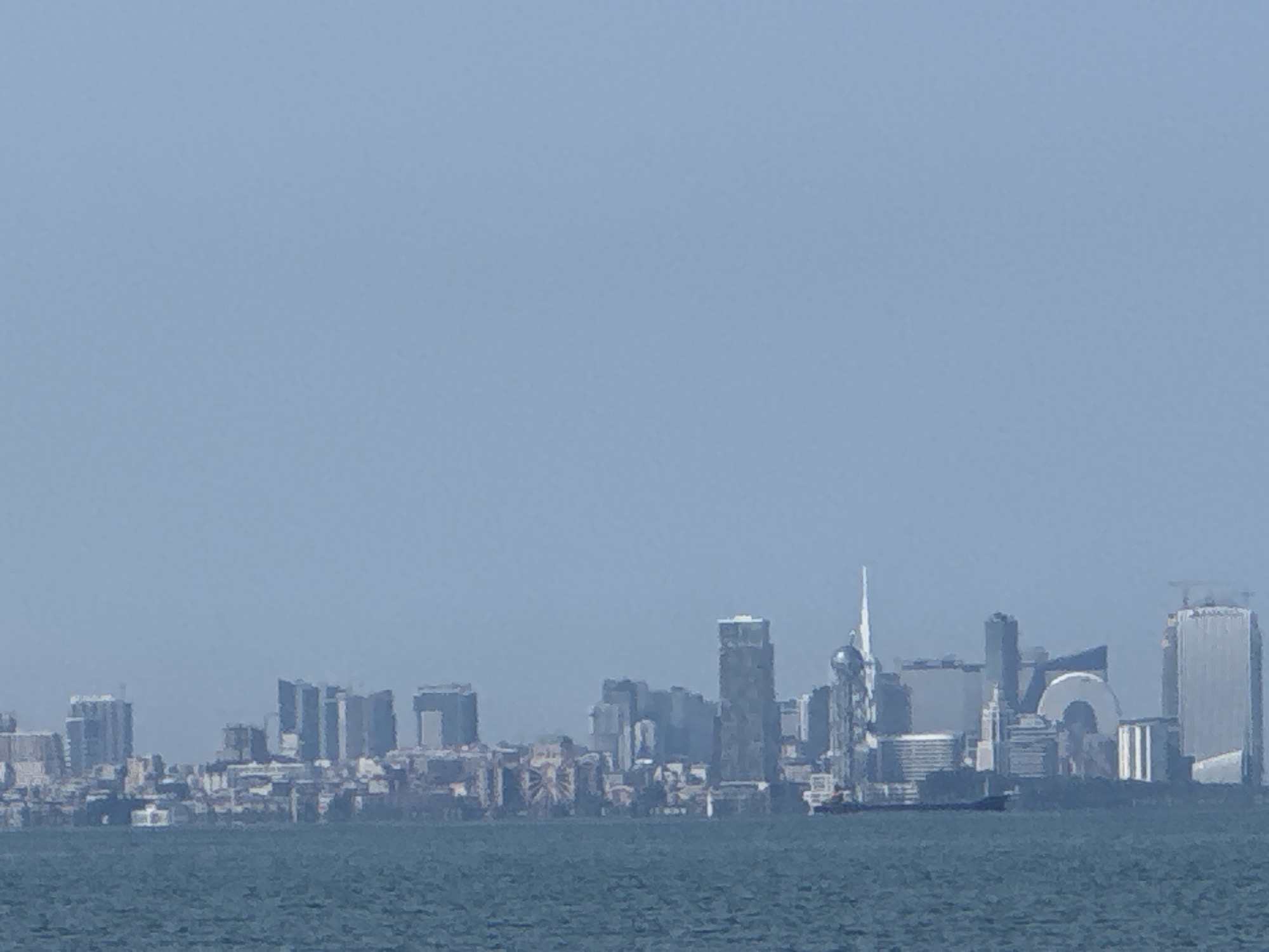 Hazy skyline of high-rises seen across the water near Chakvi