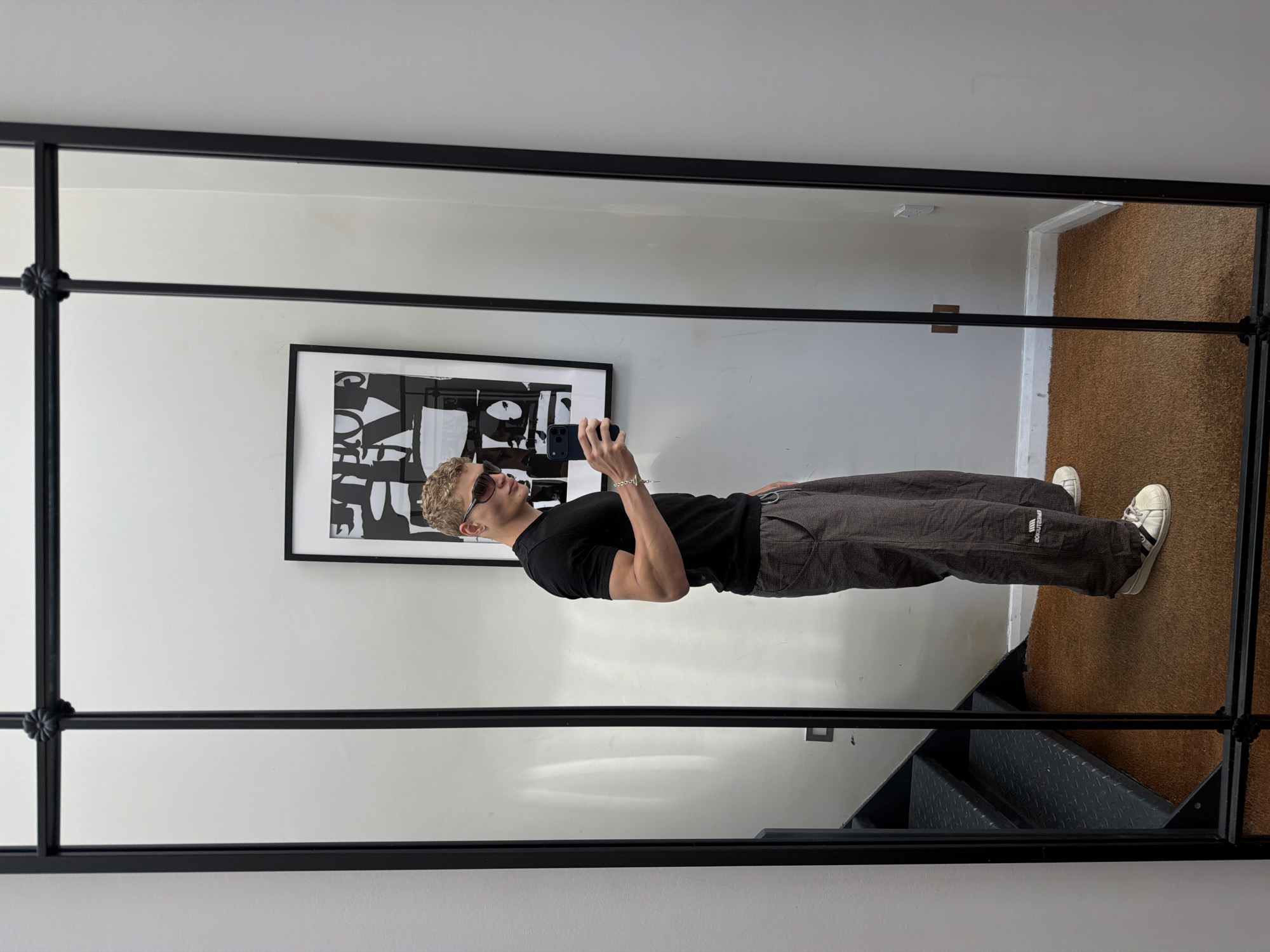 Mirror selfie in a black-framed multi-paned mirror, London